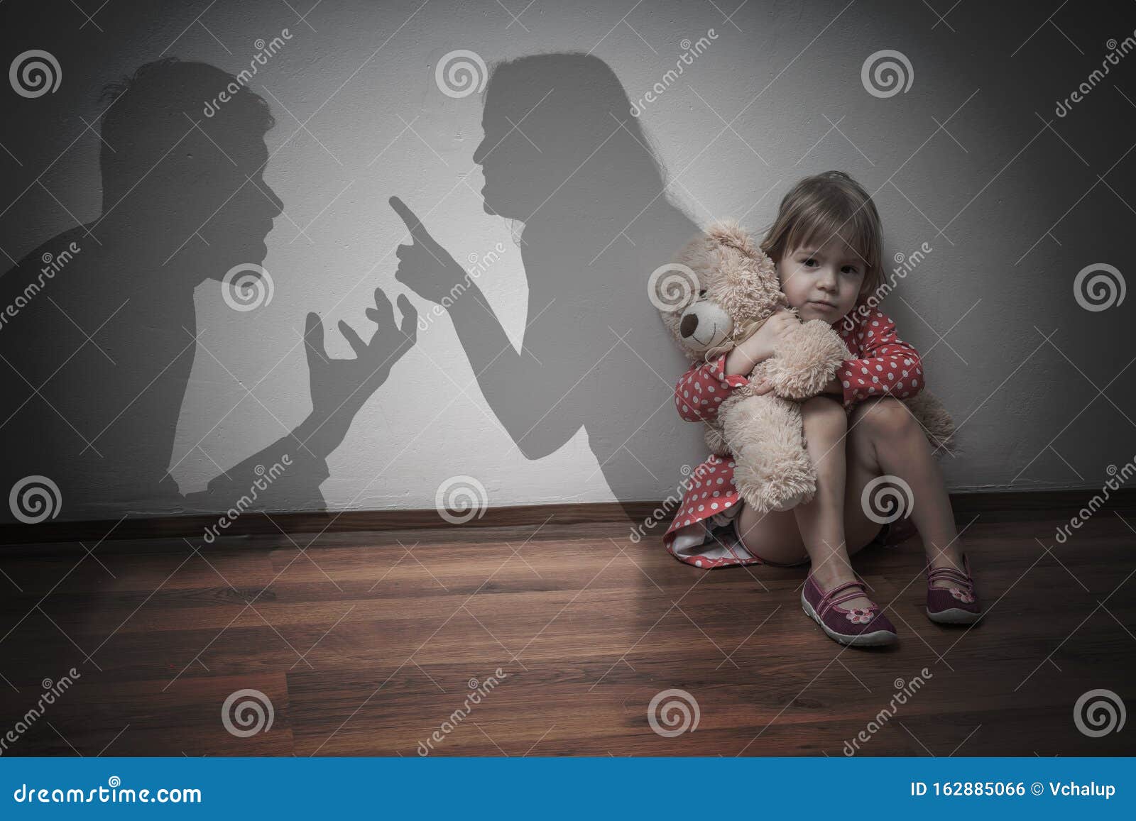 divorce concept. sad child is sitting at floor when parents argue.
