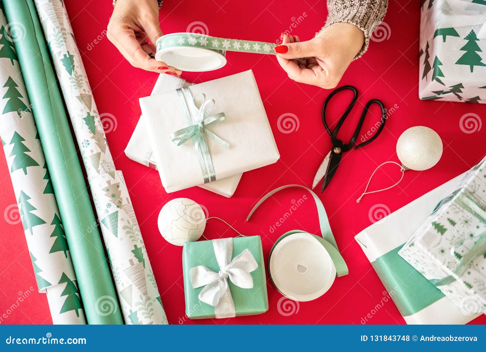diy gift wrapping. unrecognisable woman wrapping beautiful nordic style christmas gifts. hands close up.