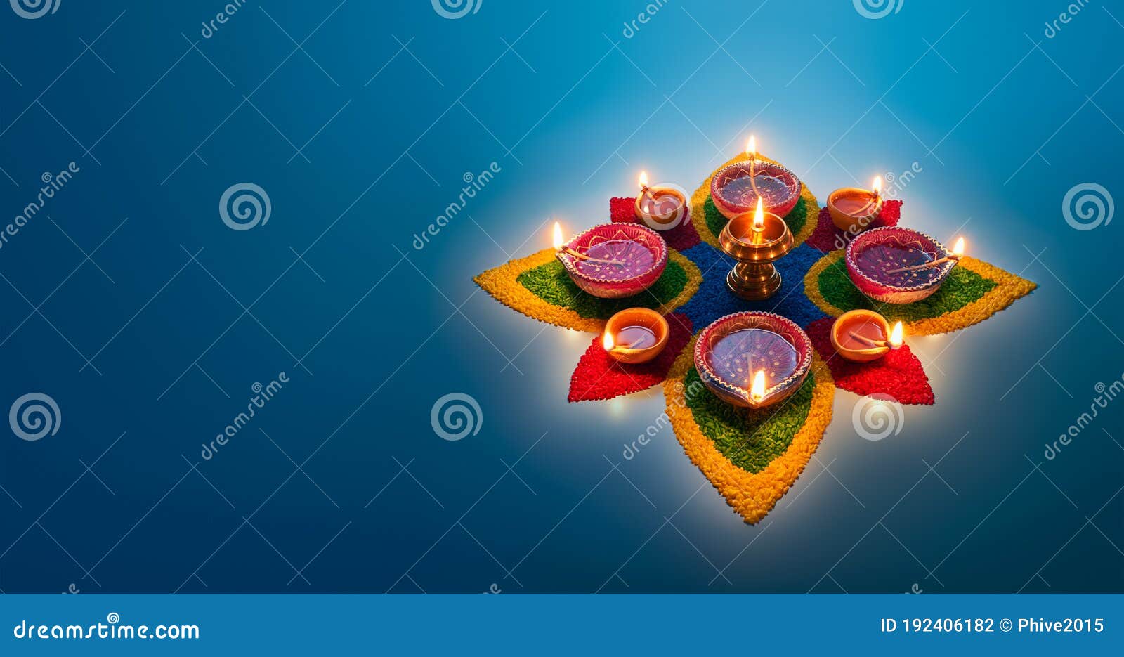 diya lamps lit on colorful rangoli