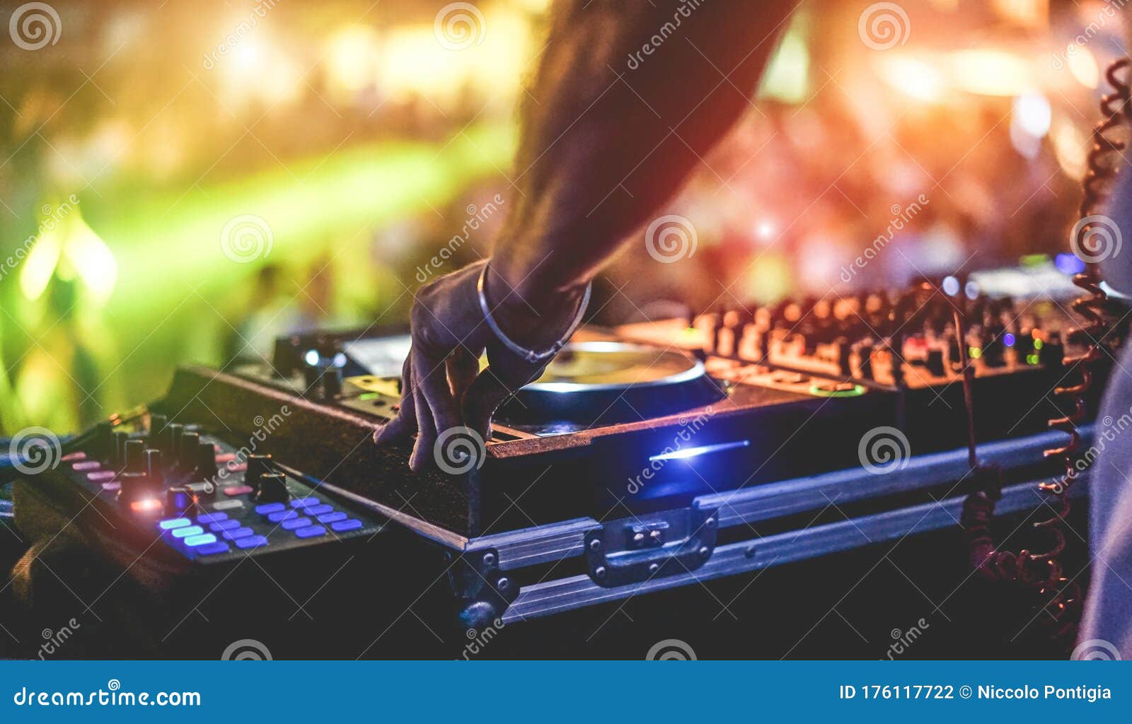 dj mixing outdoor at beach party festival with crowd of people in background - summer nightlife view of disco club outside - soft
