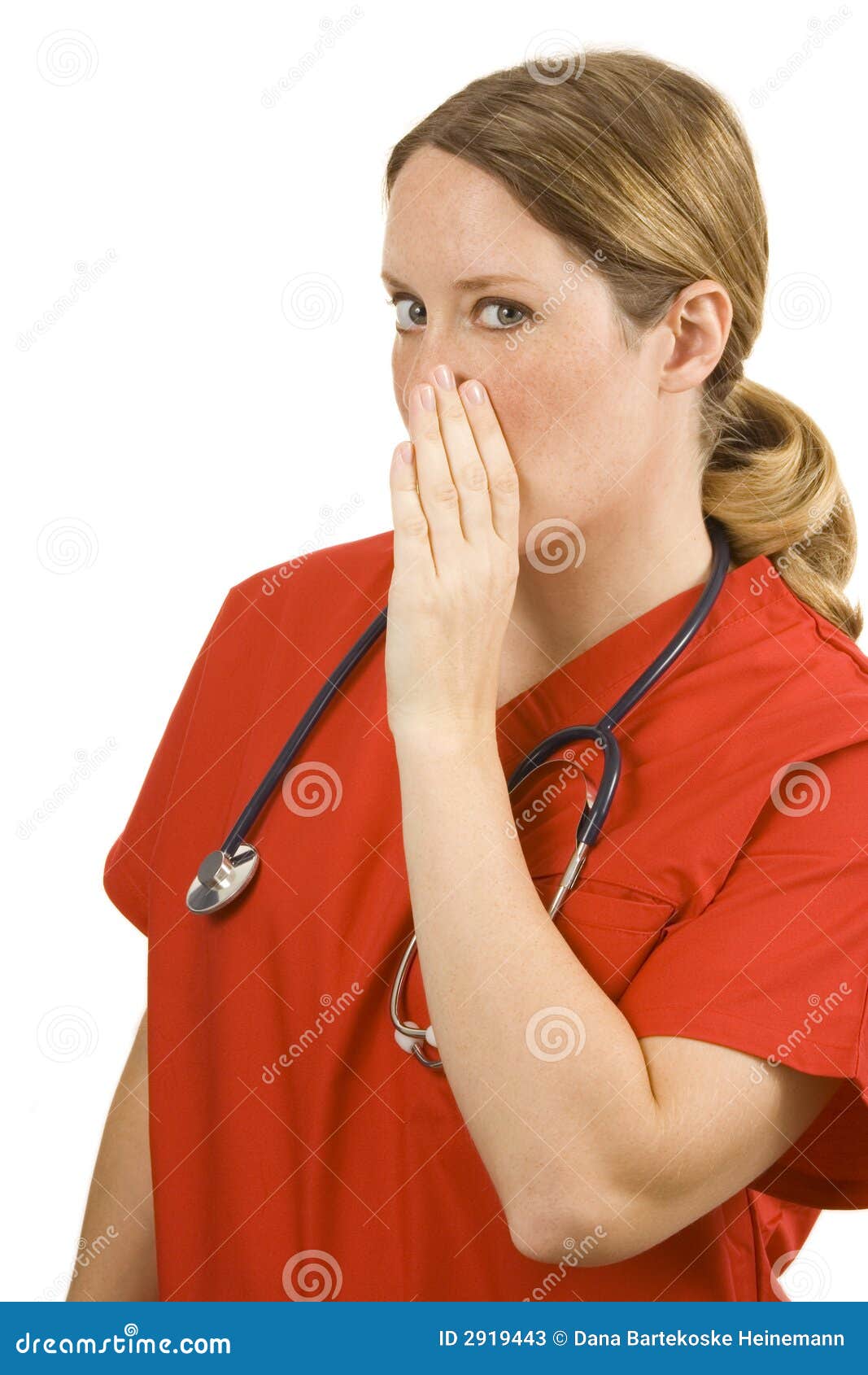 Female doctor in orange scrubs holding hand to mouth in a whisper