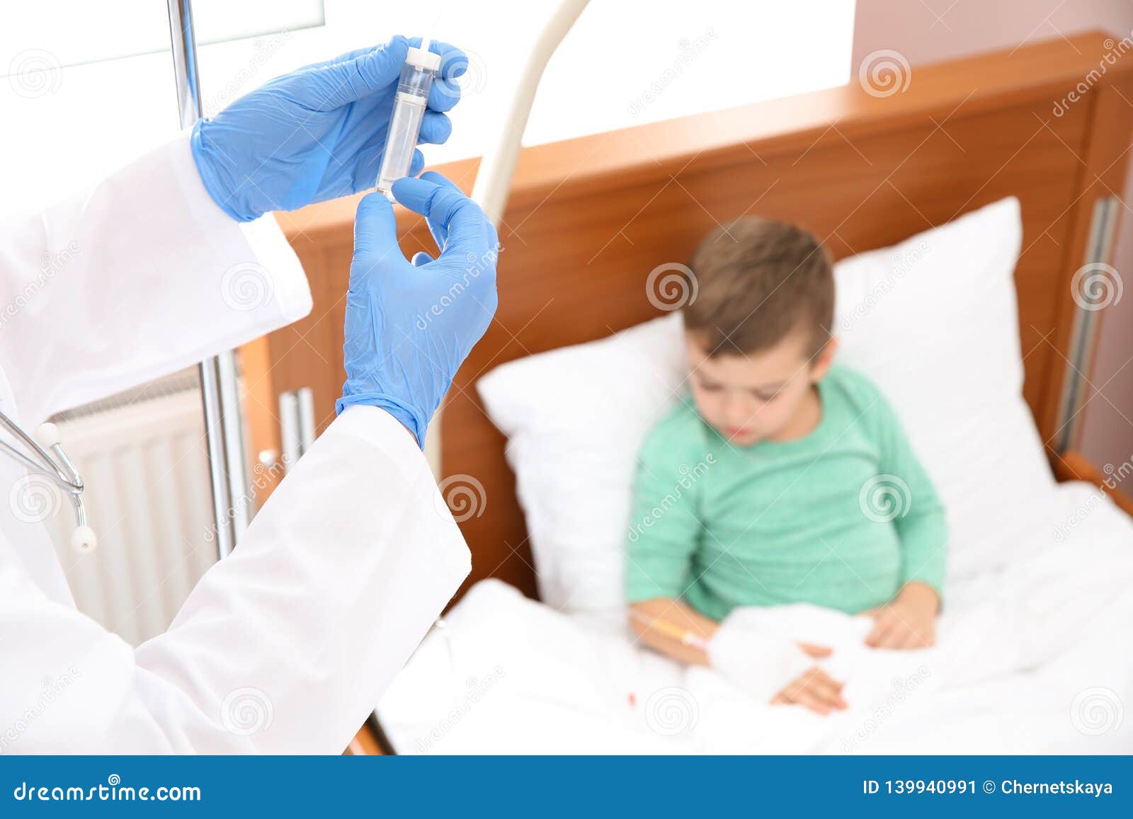 Doctor Adjusting Intravenous Drip For Little Child In Hospital Stock