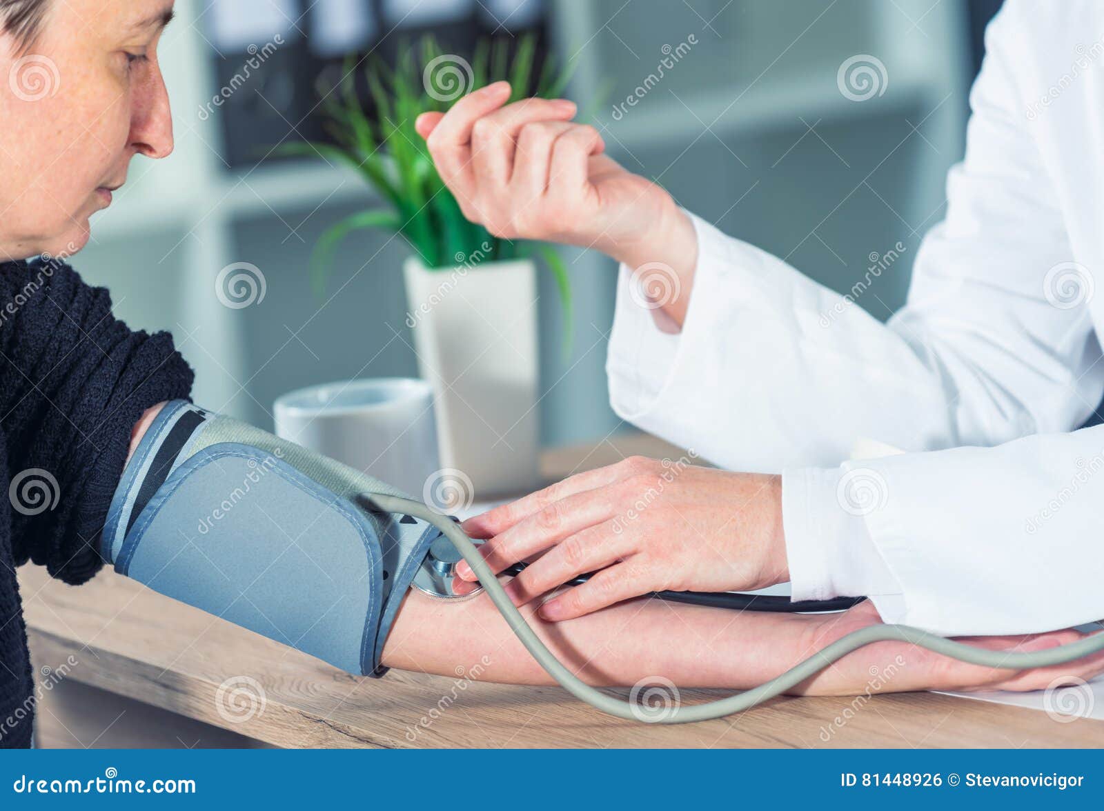 doctor cardiologist measuring blood pressure of female patient