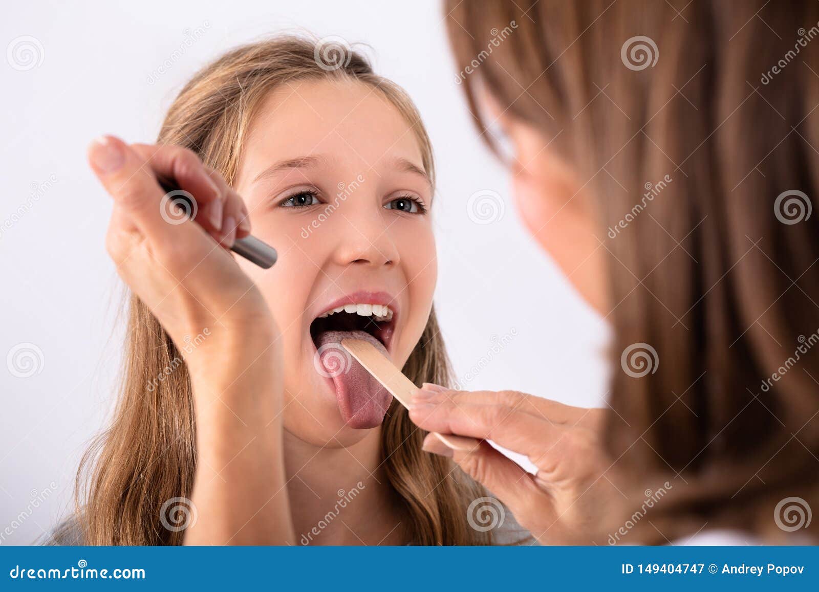 doctor checking girl`s sore throat