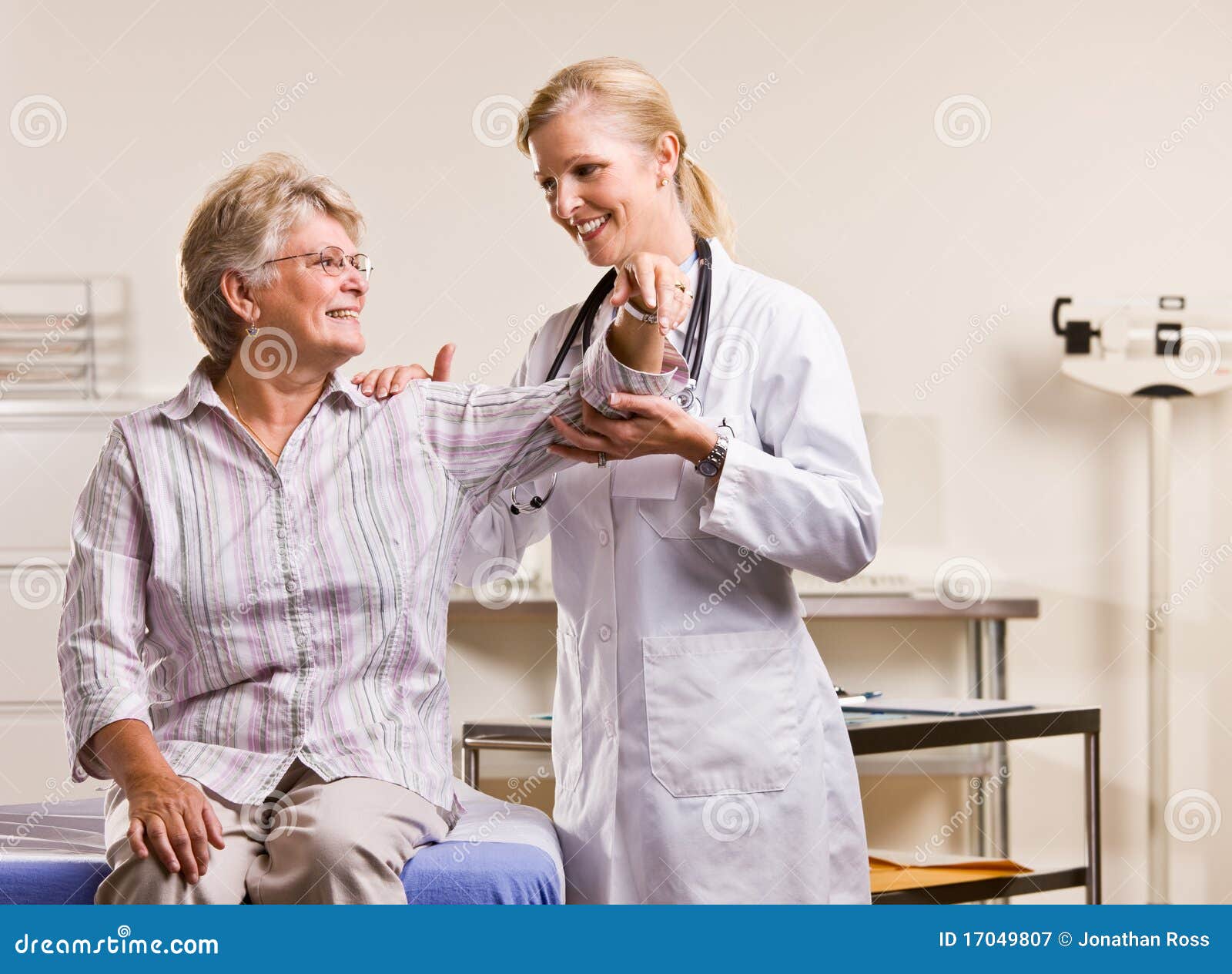 Doctor Checking Senior Woman Arm Stock Image Image of attired