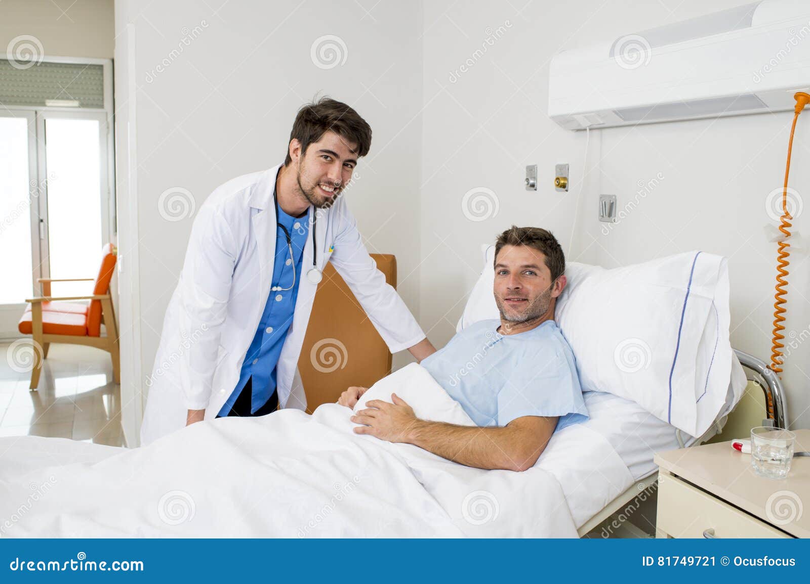 doctor consulting patient lying on hospital bed talking about the diagnose and treatment in modern clinic