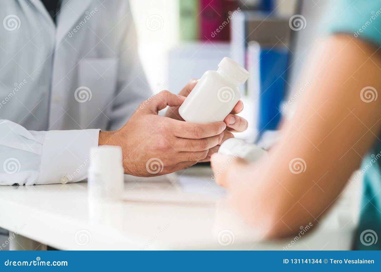 doctor consulting patient about right medication. physician holding medicine and pills in hand.
