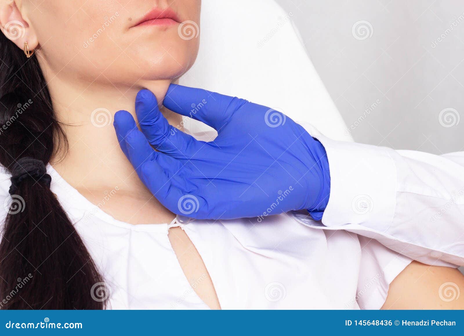 doctor cosmetologist checks the skin for elasticity on a double chin in a girl, close-up, cosmetology, resilience