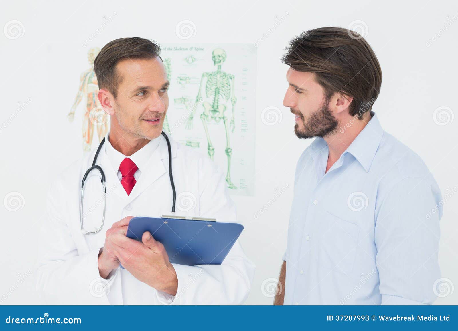 Doctor de sexo masculino que discute informes con el paciente en la oficina médica