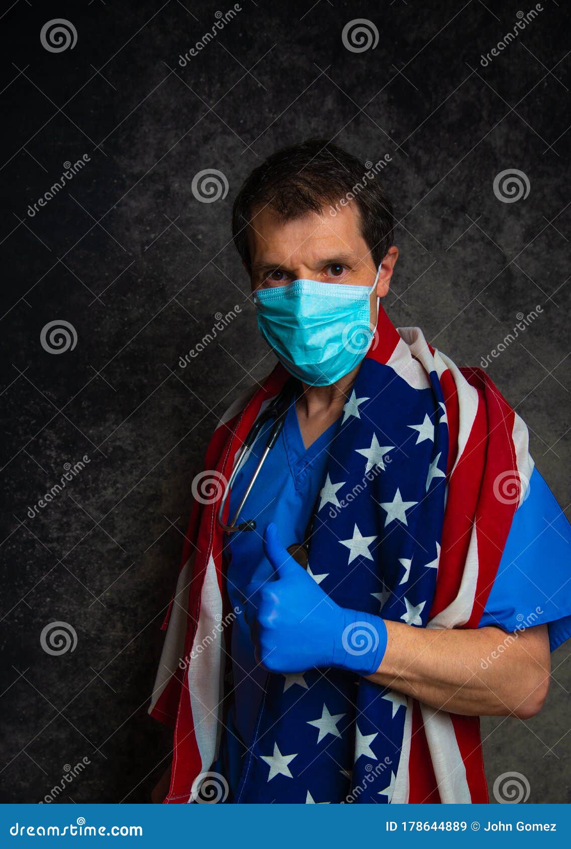 Doctor Giving a Thumbs Up Sign, Wearing Face Mask and Holding the ...