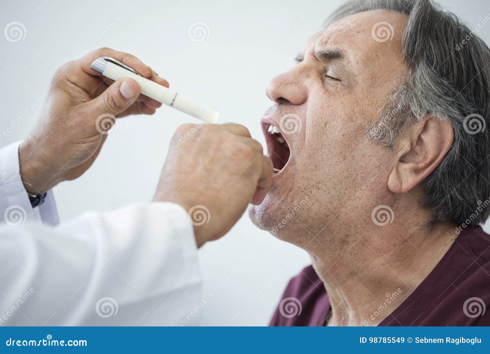 doctor examines senior man for sore throat