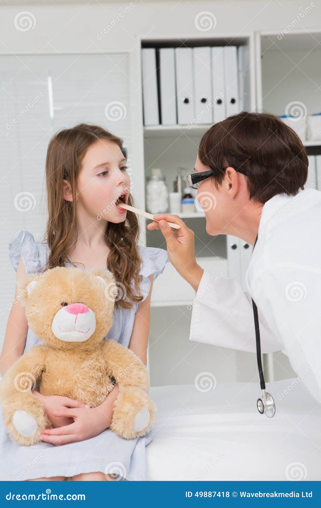 doctor examining little girl mouth
