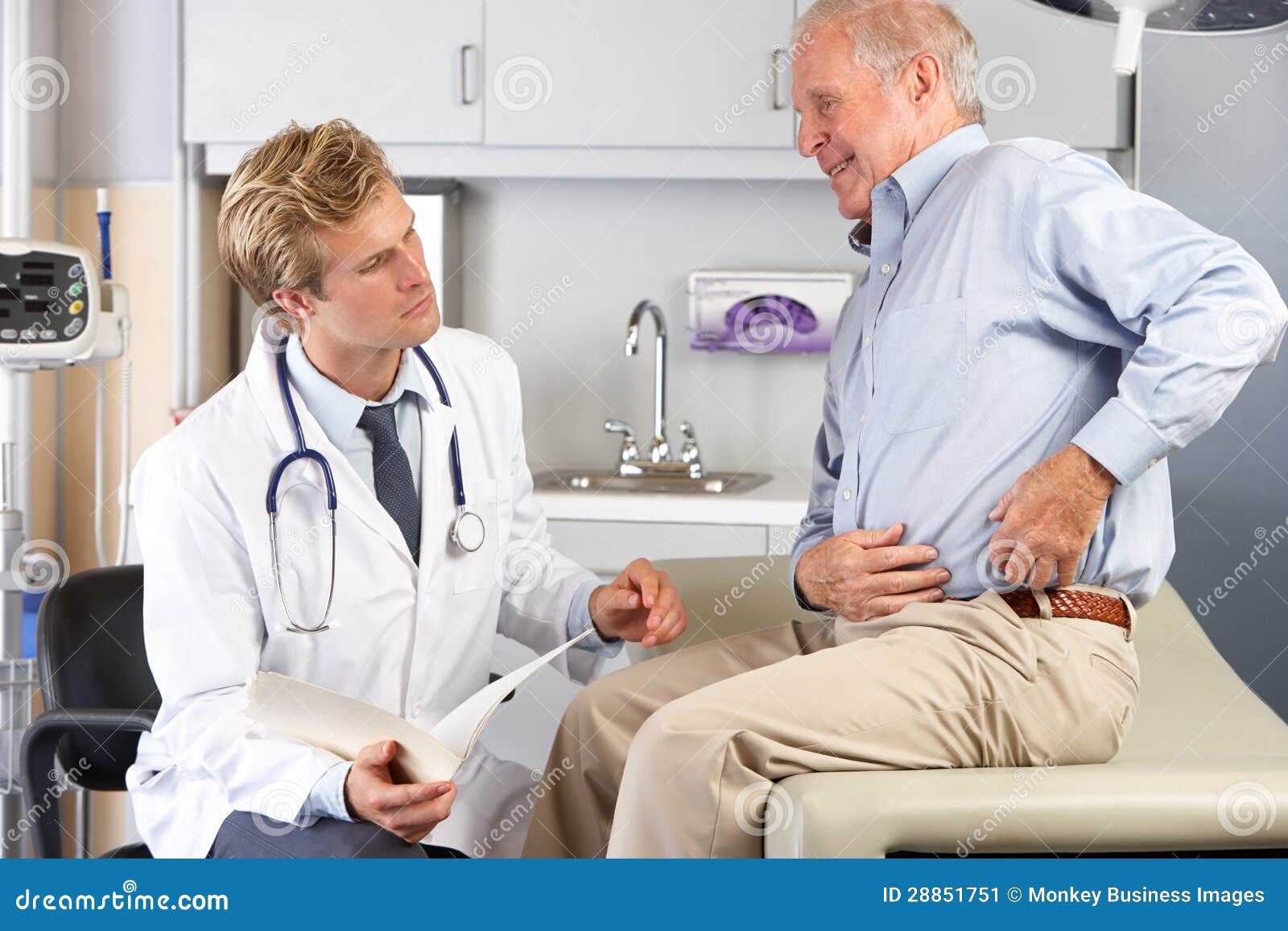 doctor examining male patient with hip pain