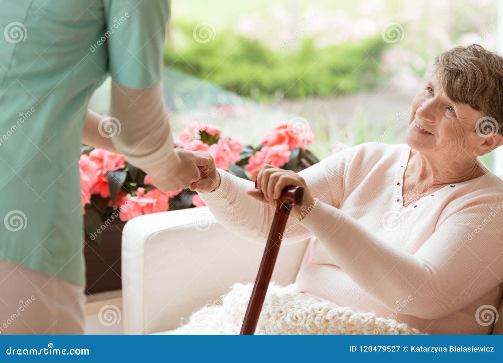 doctor helping an elderly woman with parkinson`s disease get up