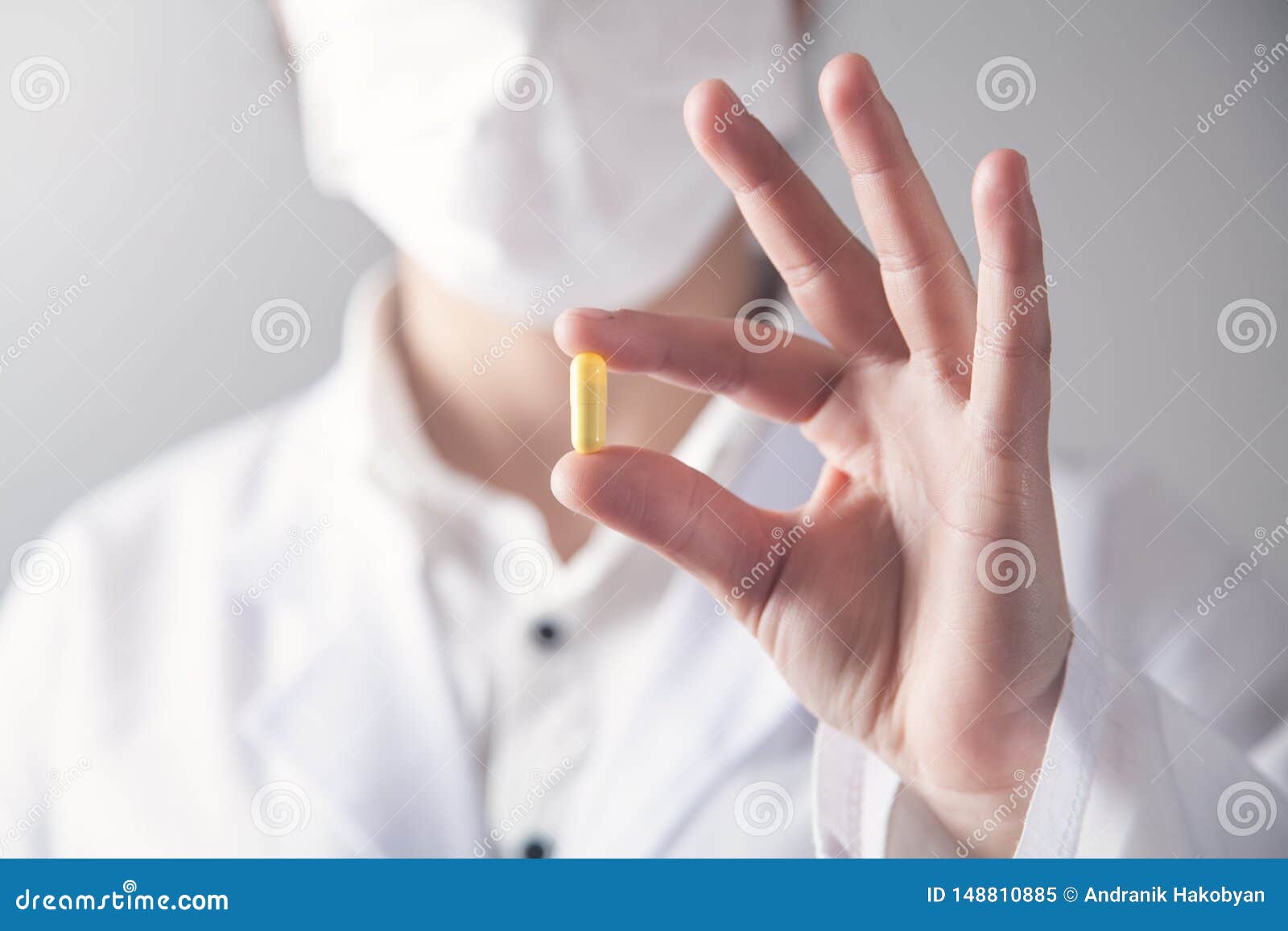 doctor holds yellow pill in his hand. medical concept