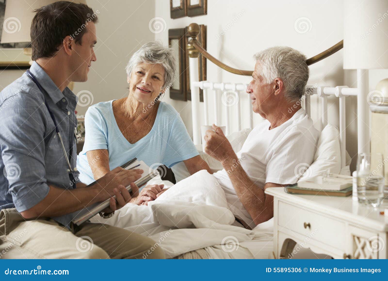 doctor on home visit discussing health of senior male patient with wife