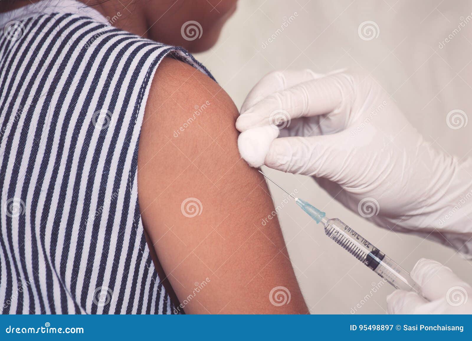 Doctor injecting vaccination in arm of asian little child girl,healthy and medical concept