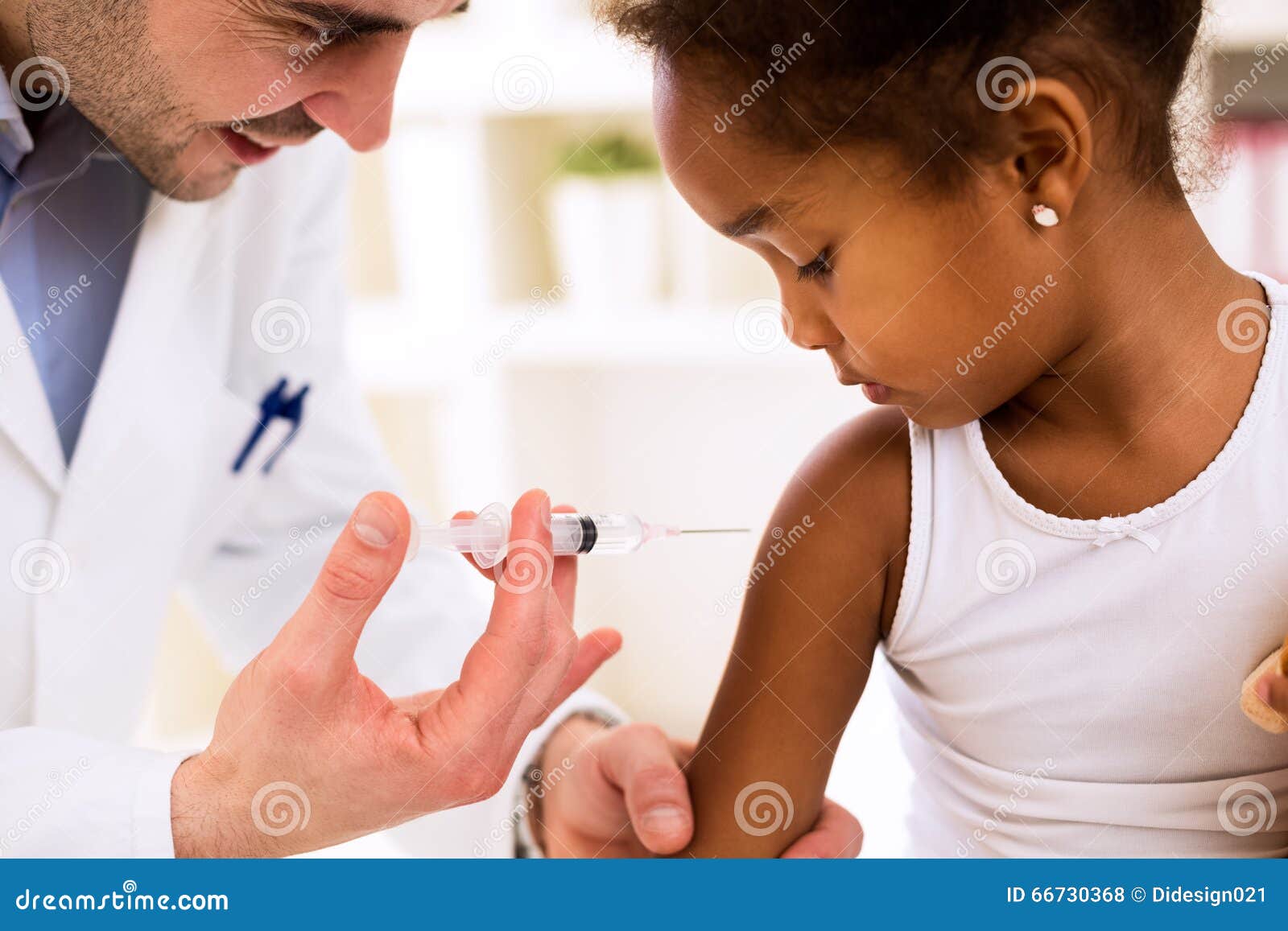 doctor injecting vaccine to cute african girl