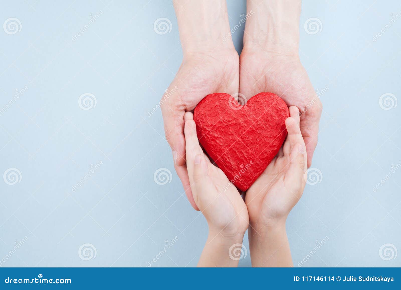 doctor and kid holding red heart in hands top view. family relationships, health care, pediatric cardiology concept.