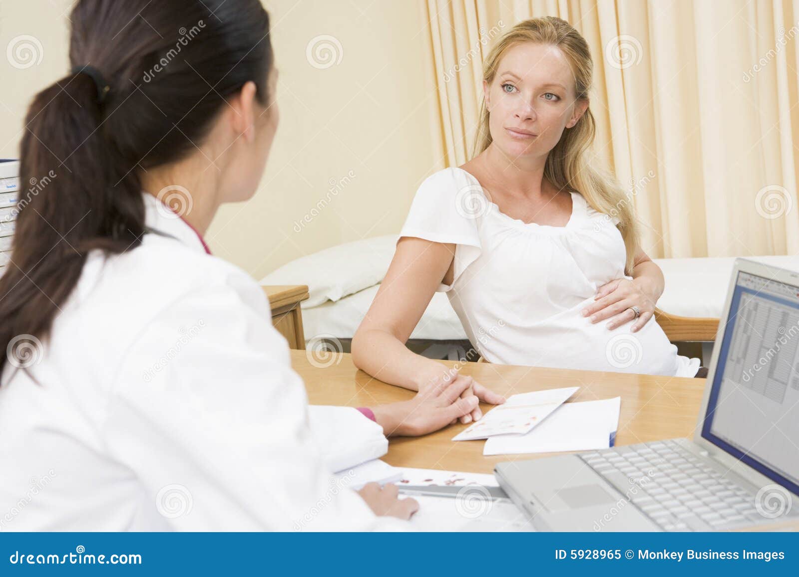 doctor with laptop and pregnant woman