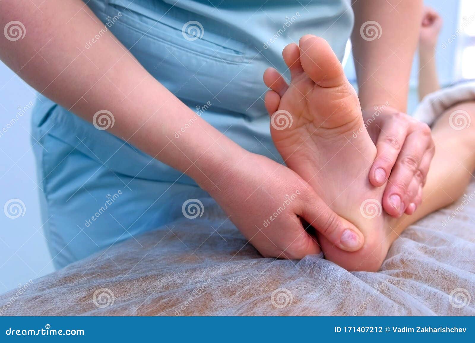 doctor massagist making therapy massage to child boy on foot in clinic, closeup.