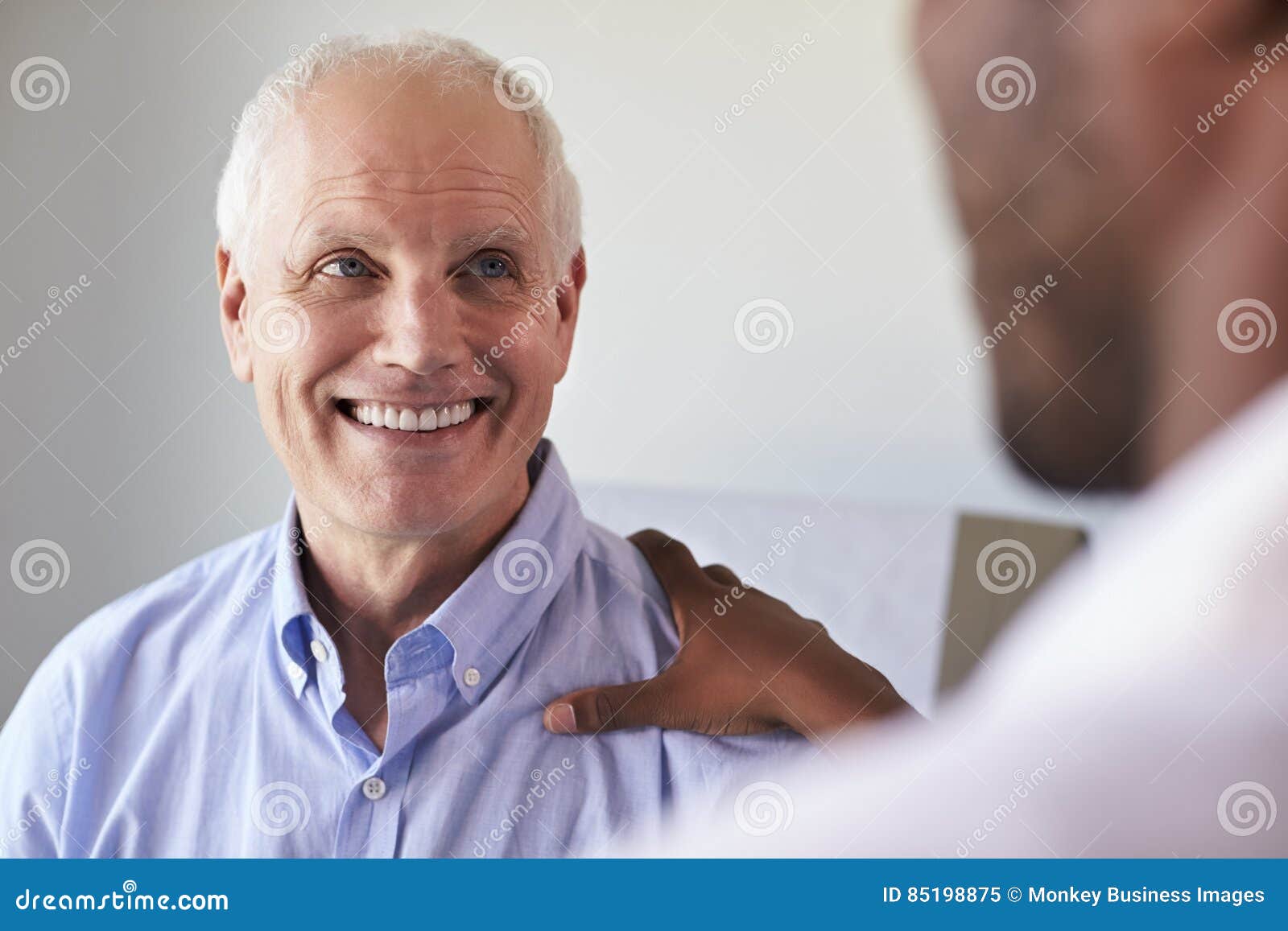 doctor meeting with mature male patient in exam room