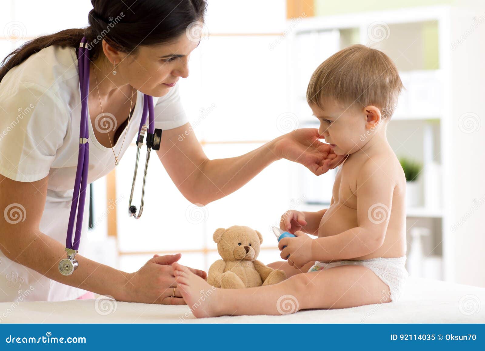doctor paediatrician checking boy`s neck