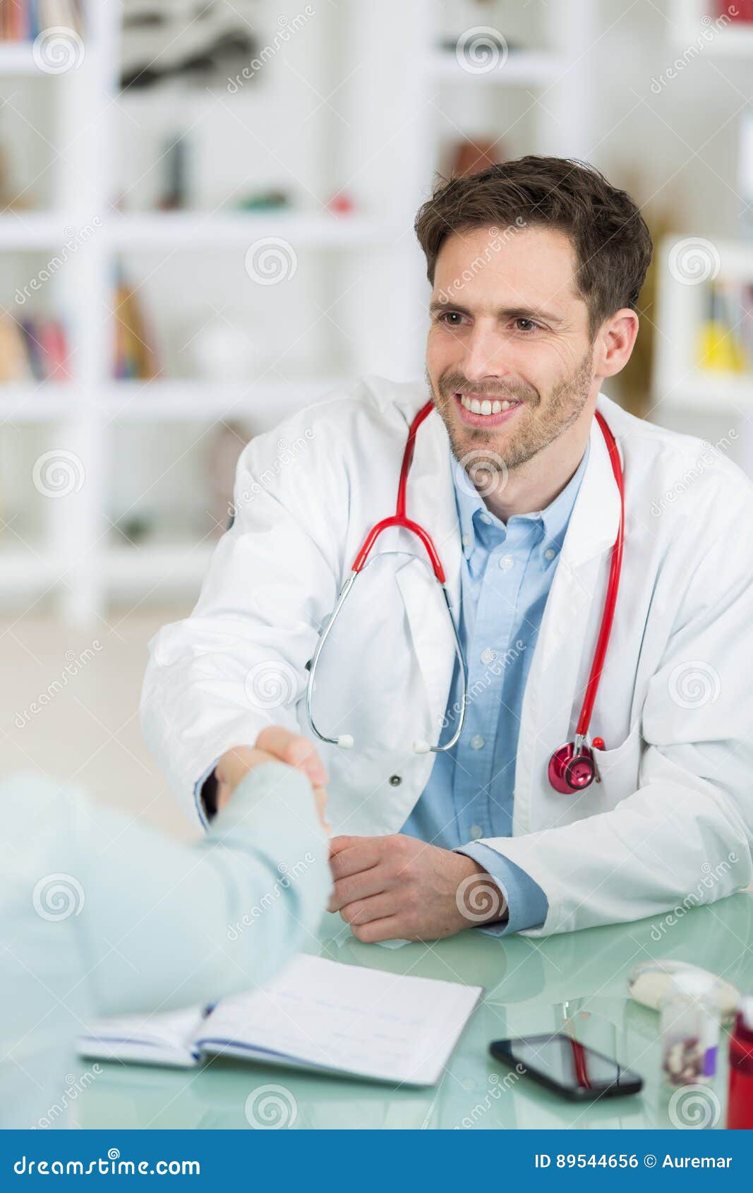 Doctor and Patient Shaking Hands in Medical Office Stock Photo Image