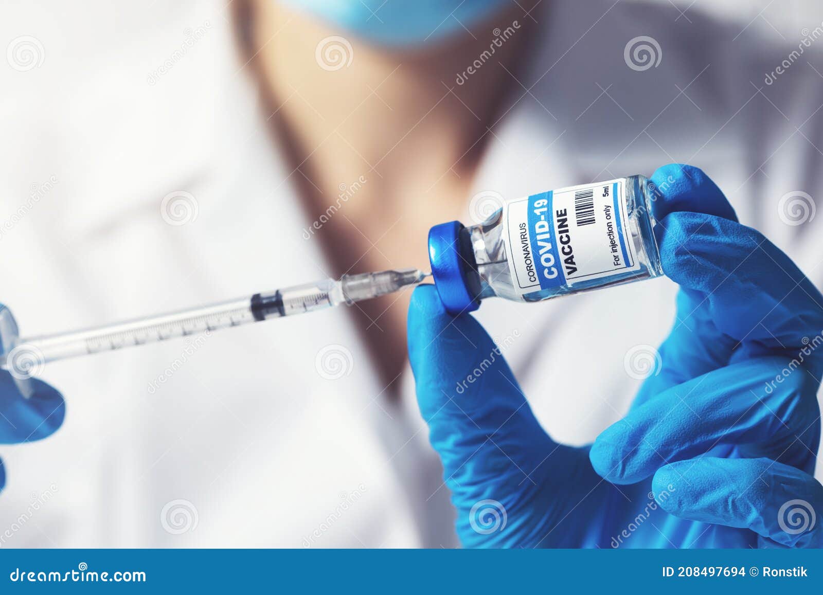 doctor preparing covid-19 vaccine dose for vaccination. closeup of syringe and vial in hands