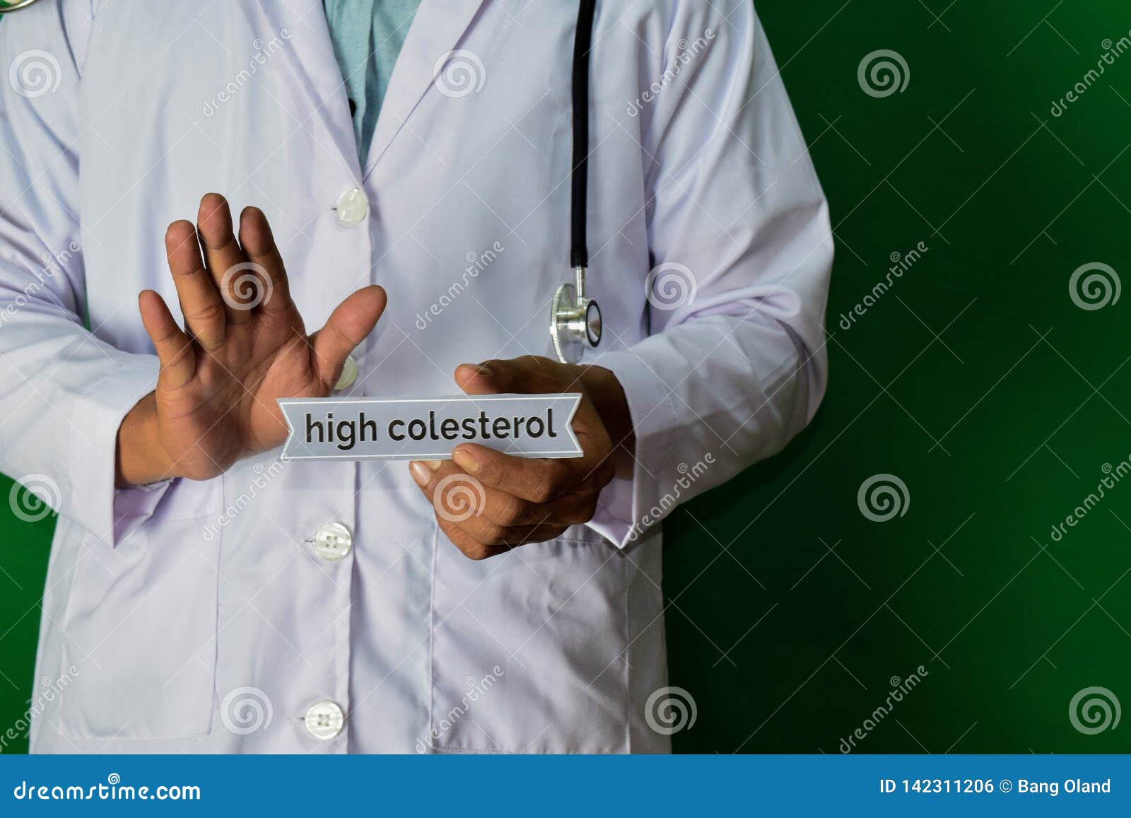 doctor standing on green background. selective focus in hand. high colesterol paper text. medical and healthcare concept
