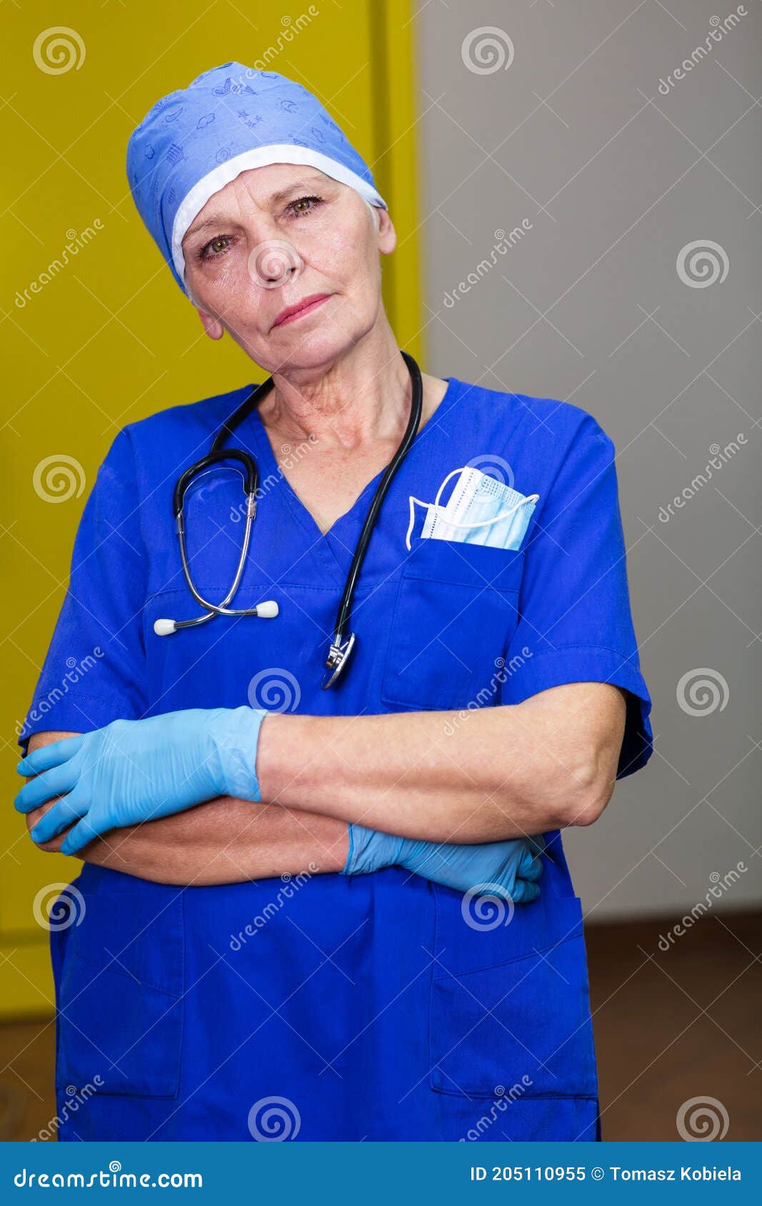 a doctor in a surgical cap wearing blue gloves and stethoscope