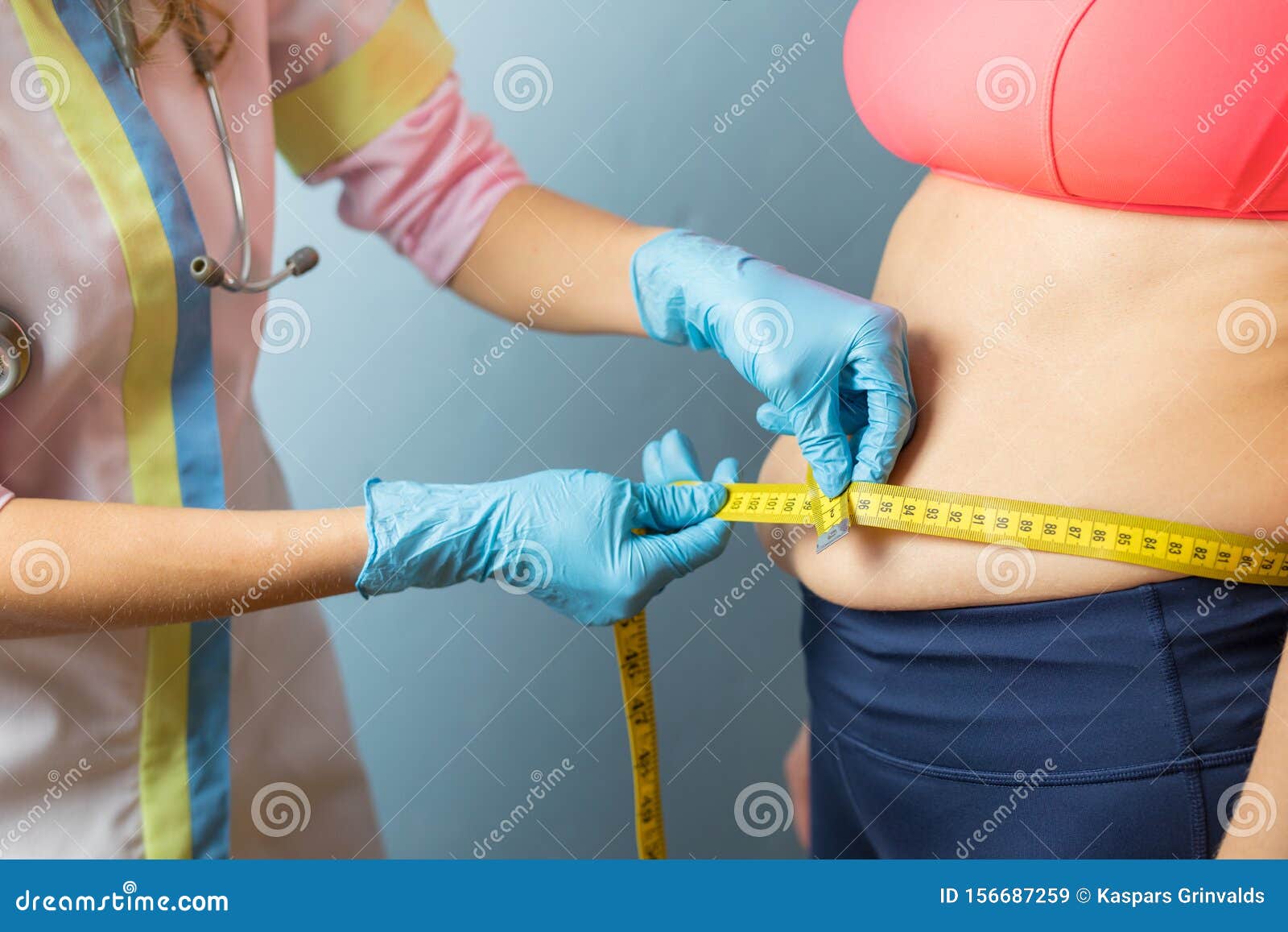 doctor taking obese woman`s body fat measurements