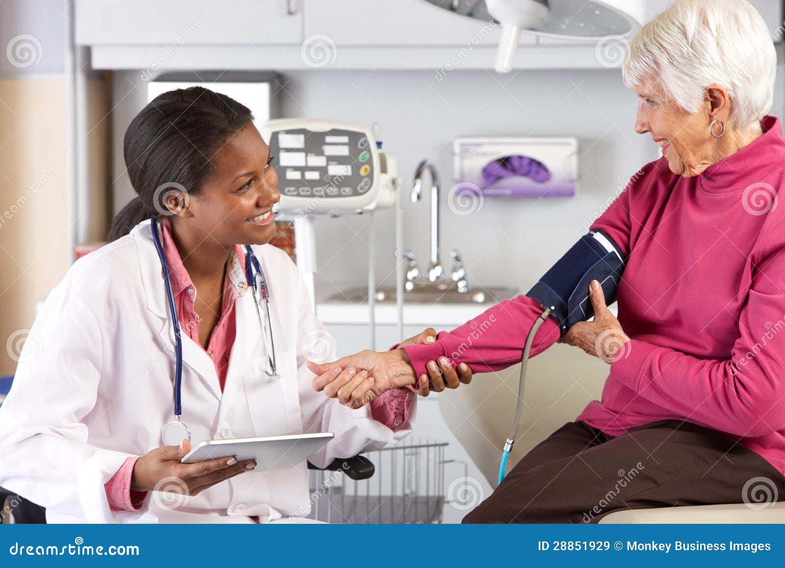 doctor taking senior female patient's blood pressure