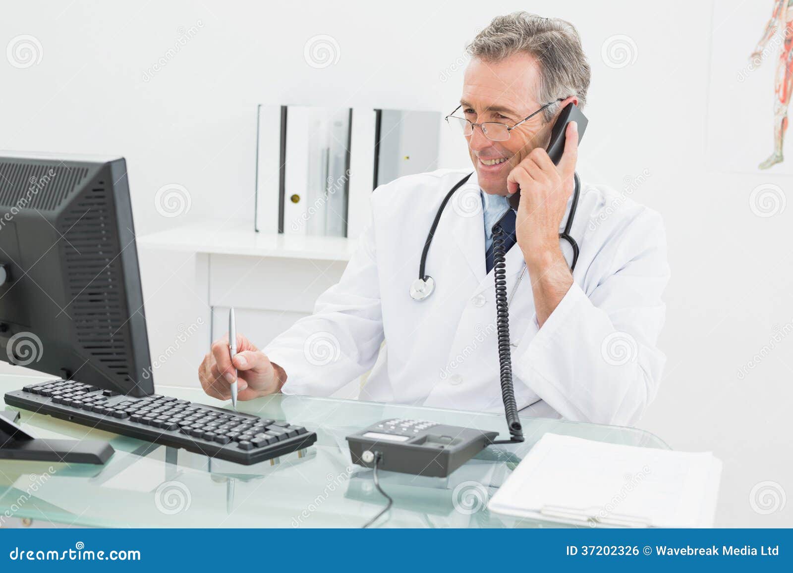 Doctor Using Computer and Telephone at Office Stock Photo Image of