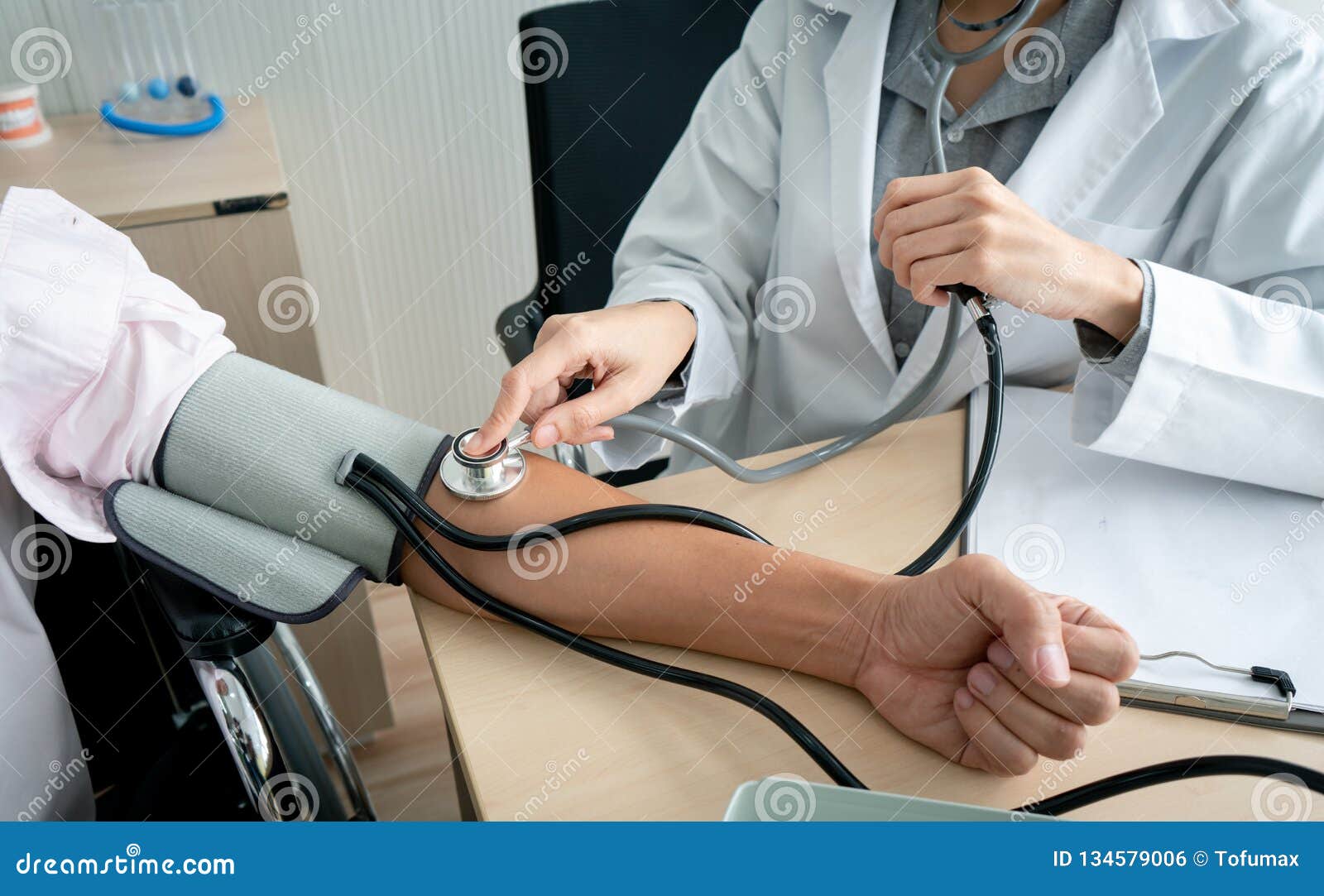doctor using sphygmomanometer checking blood pressure