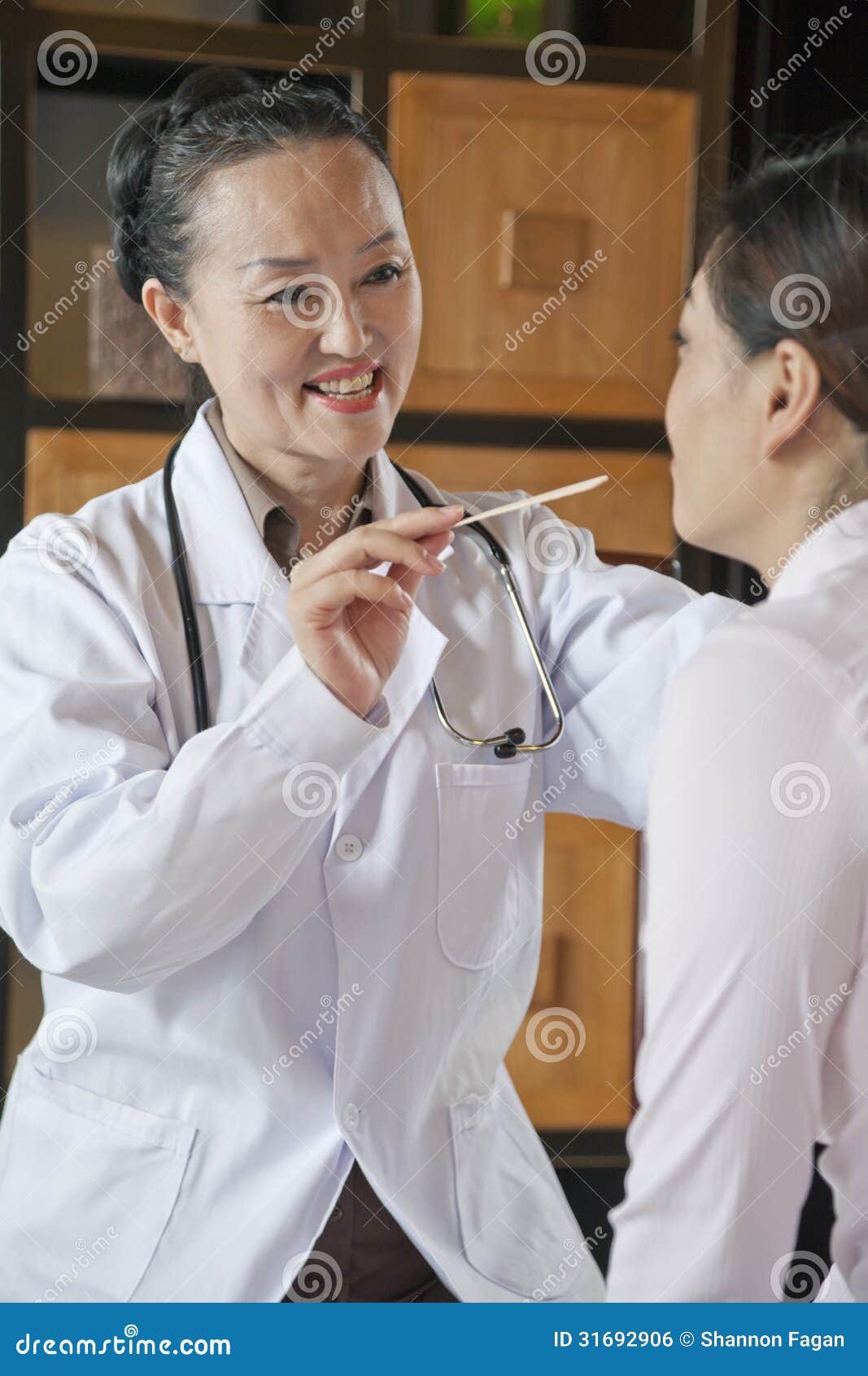 Doctor Using Tongue Depressor on Patient Stock Photo Image of