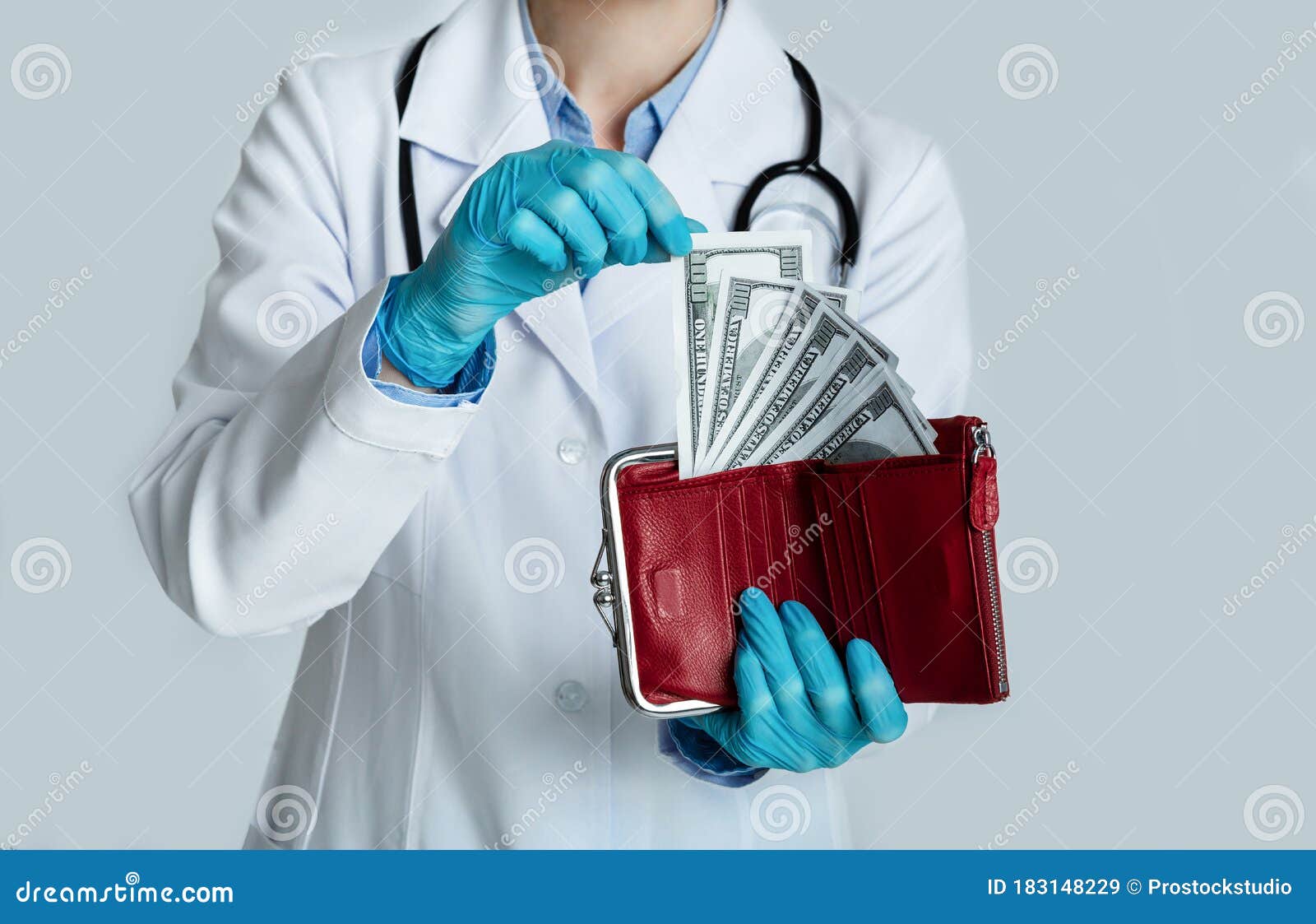 doctor in white coat holds red purse with dollars in hands and takes money