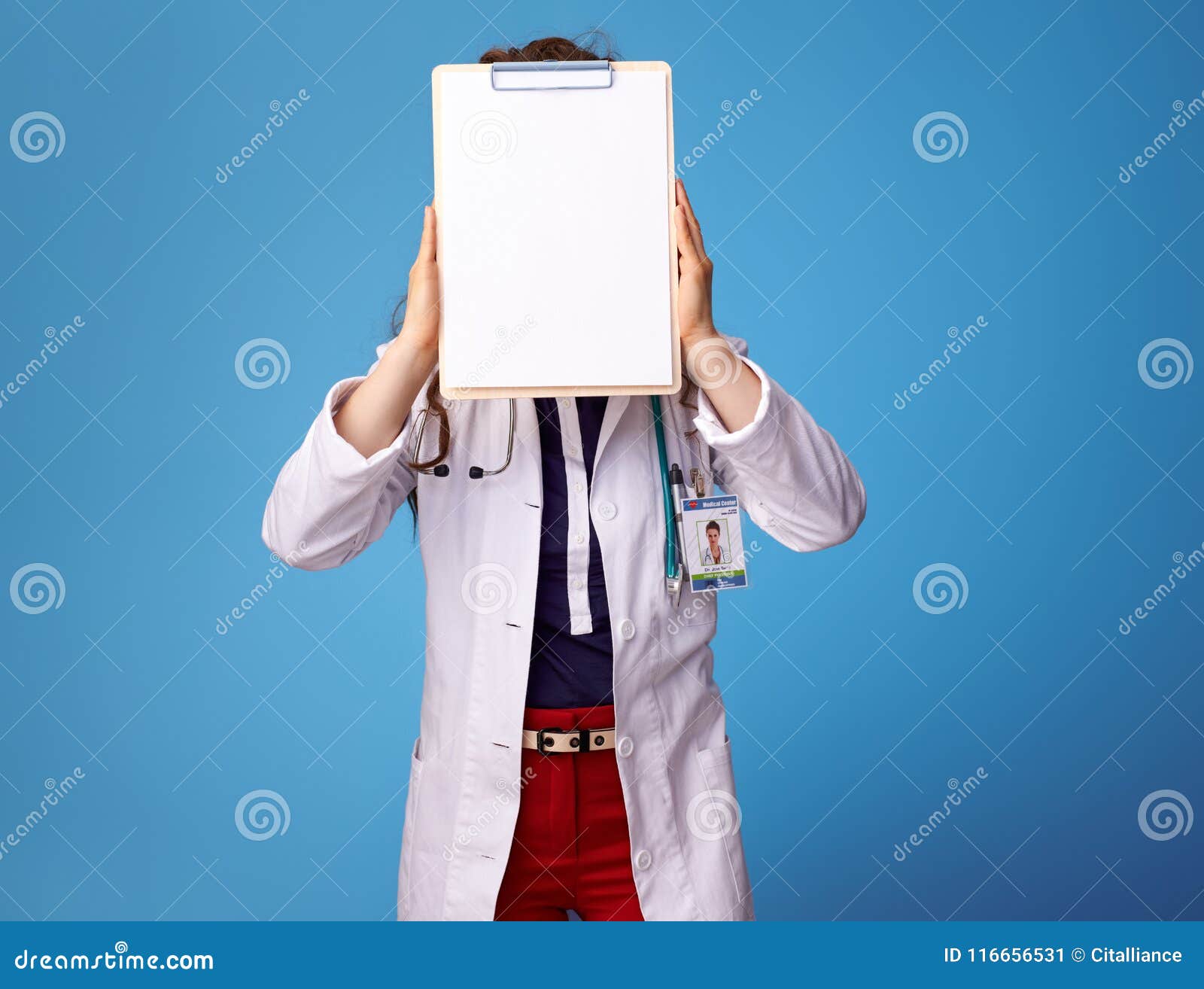 doctor woman hoding clipboards front of face on blue