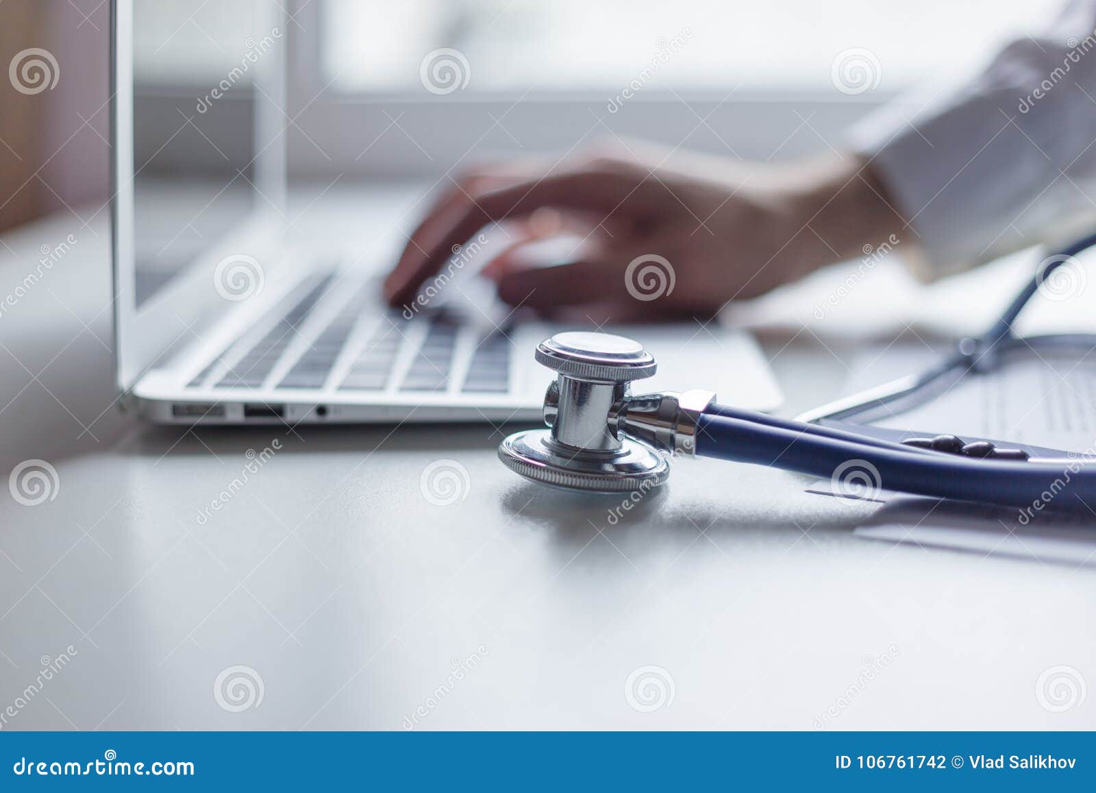 doctor working with laptop computer in medical workspace office. focus on stethoscope