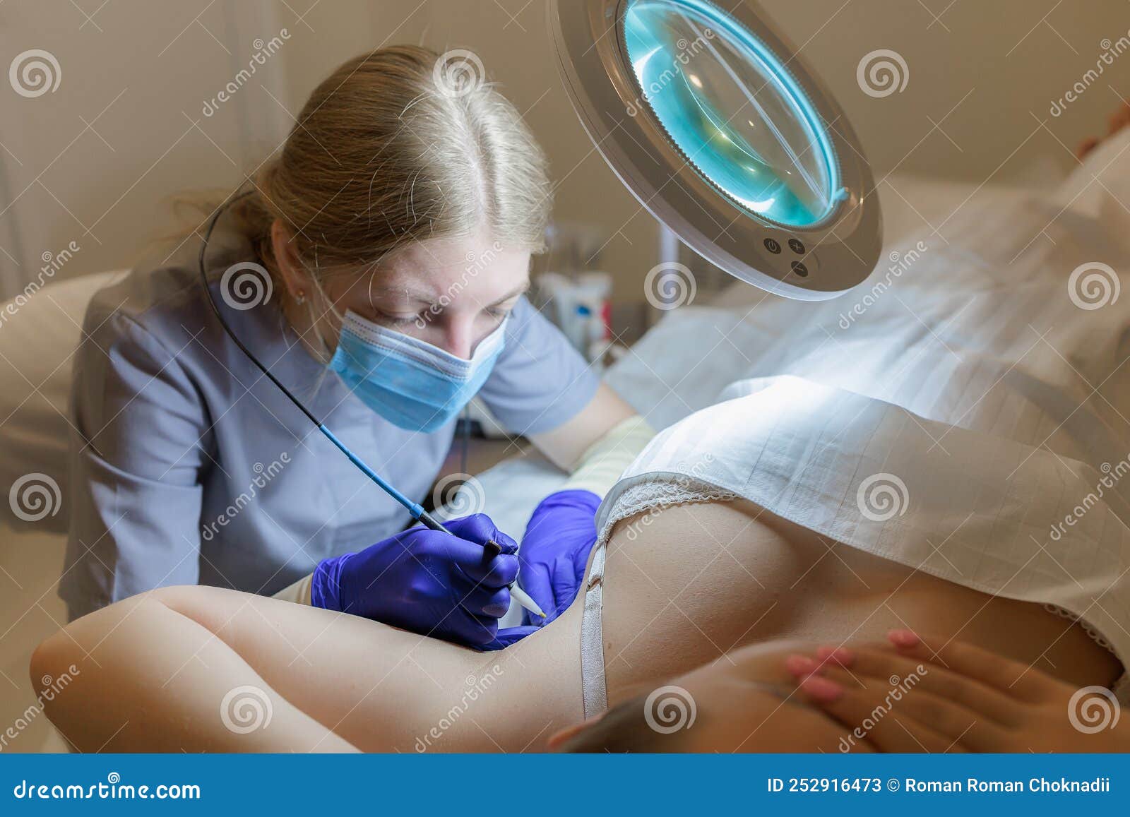 The Doctor Works Under the Client`s Armpit Removing Unwanted Hairs