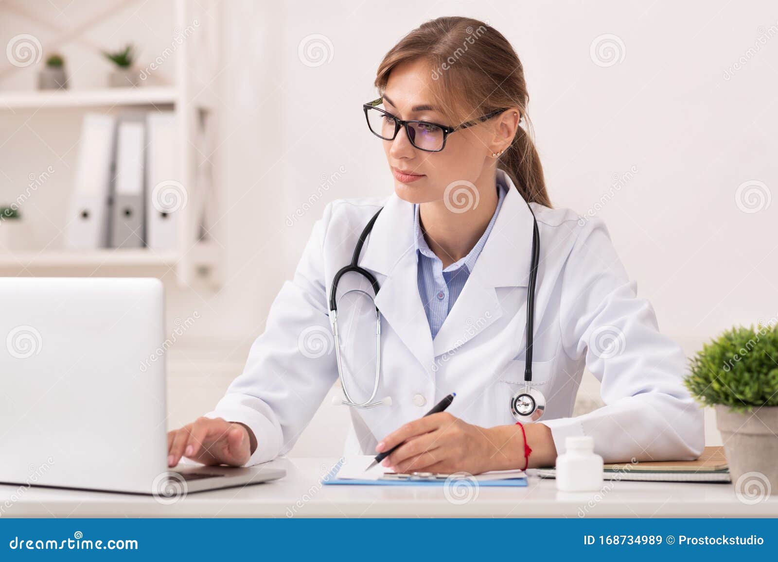 Doctora Mujer Trabajando En Portátil Tomando Notas Sentada En La Oficina  Imagen de archivo - Imagen de escritorio, hospital: 168734989