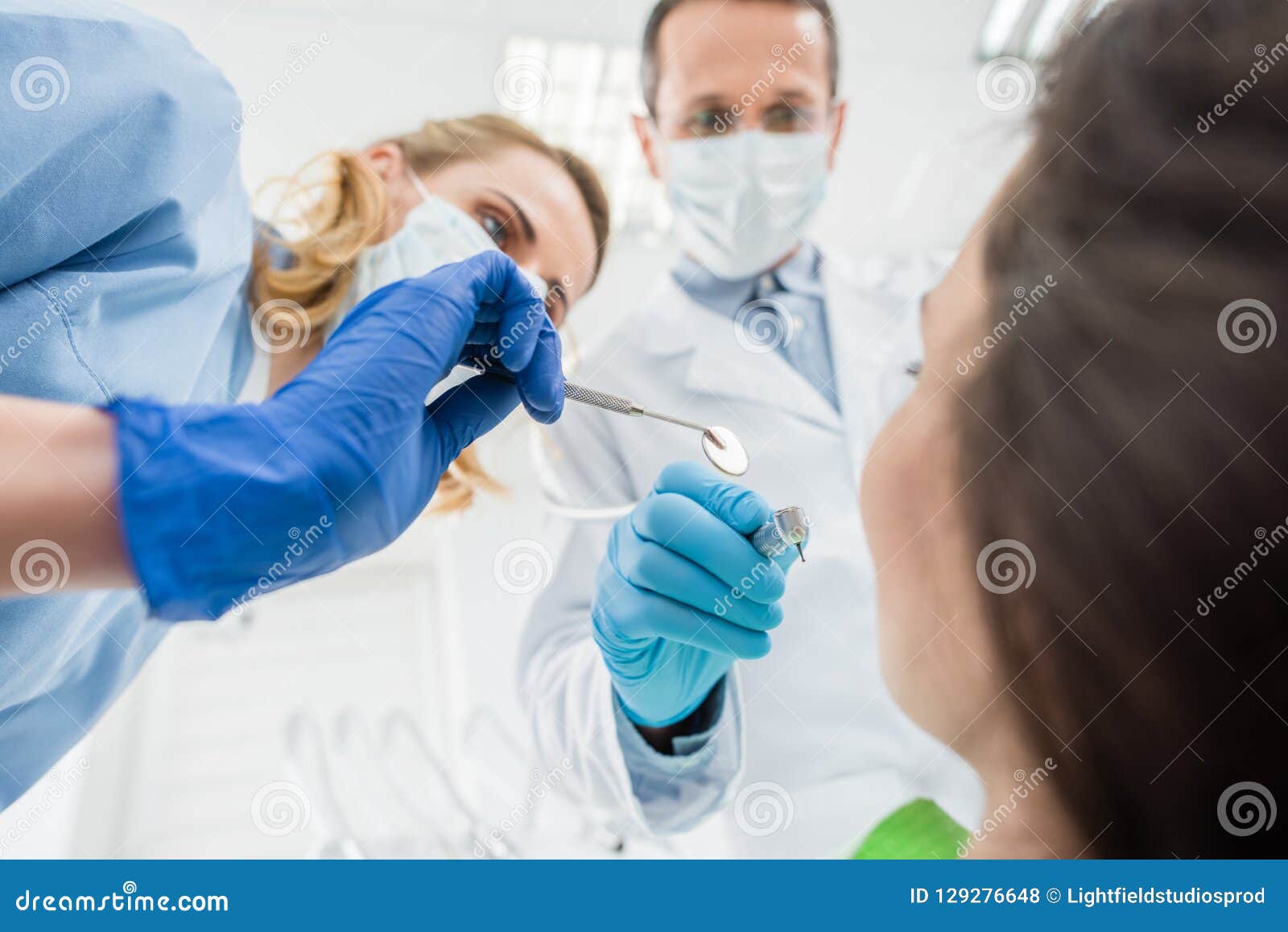 Doctors Checking Patient Teeth with Mirror in Modern Stock Photo