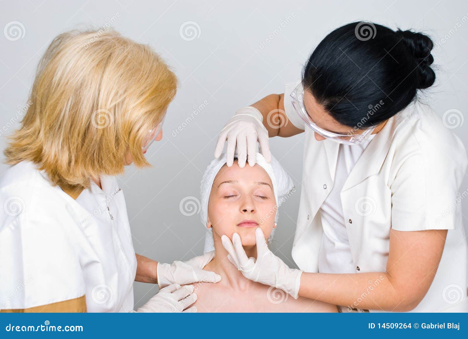 doctors examine woman face skin