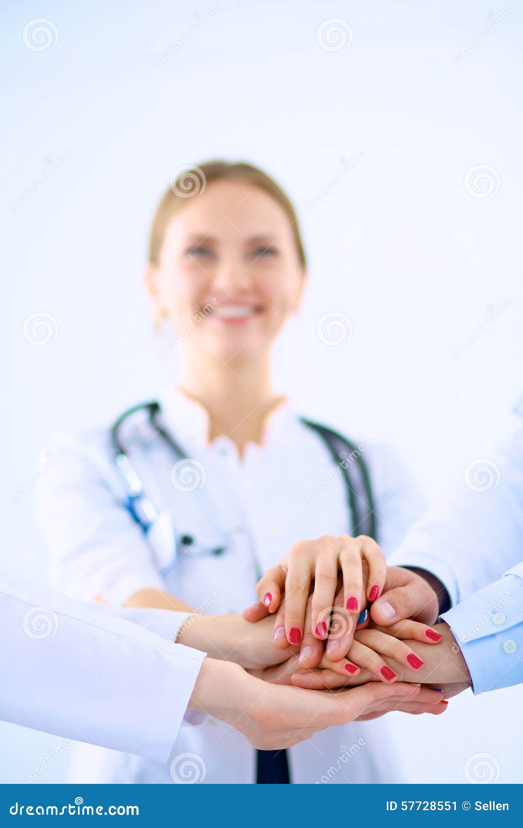 Doctors and nurses in a medical team stacking hands .