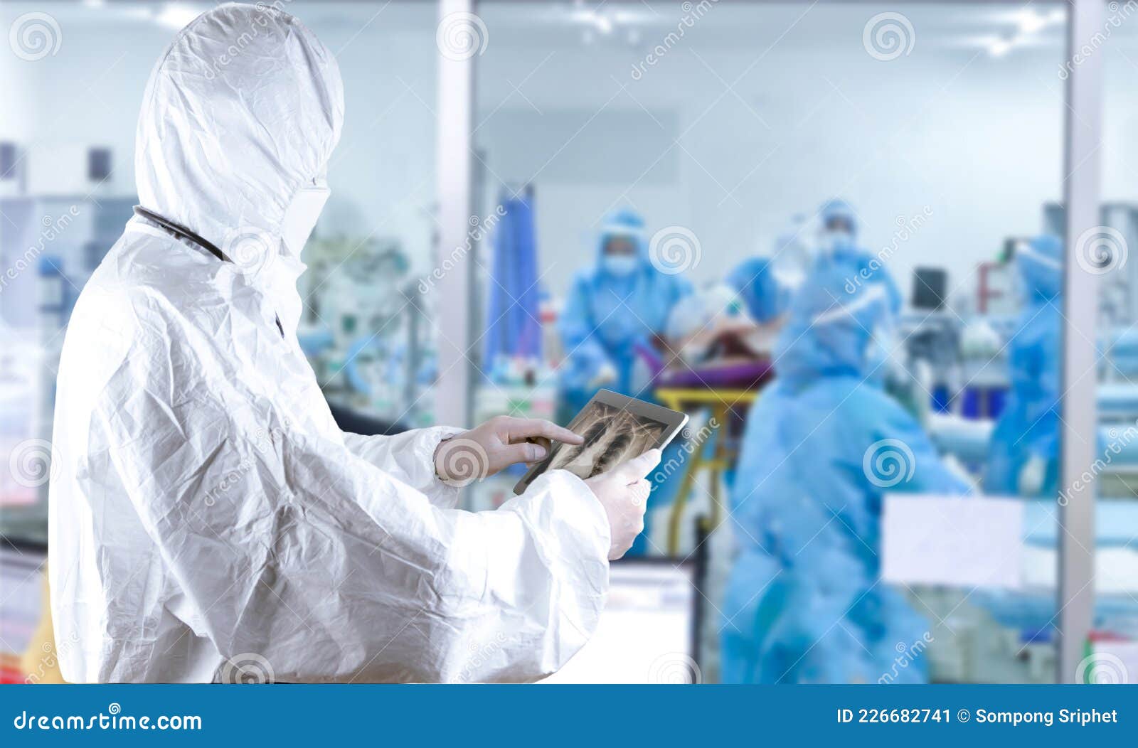 Doctors in the Protective Suits and Masks Holding Tablet are Examining ...