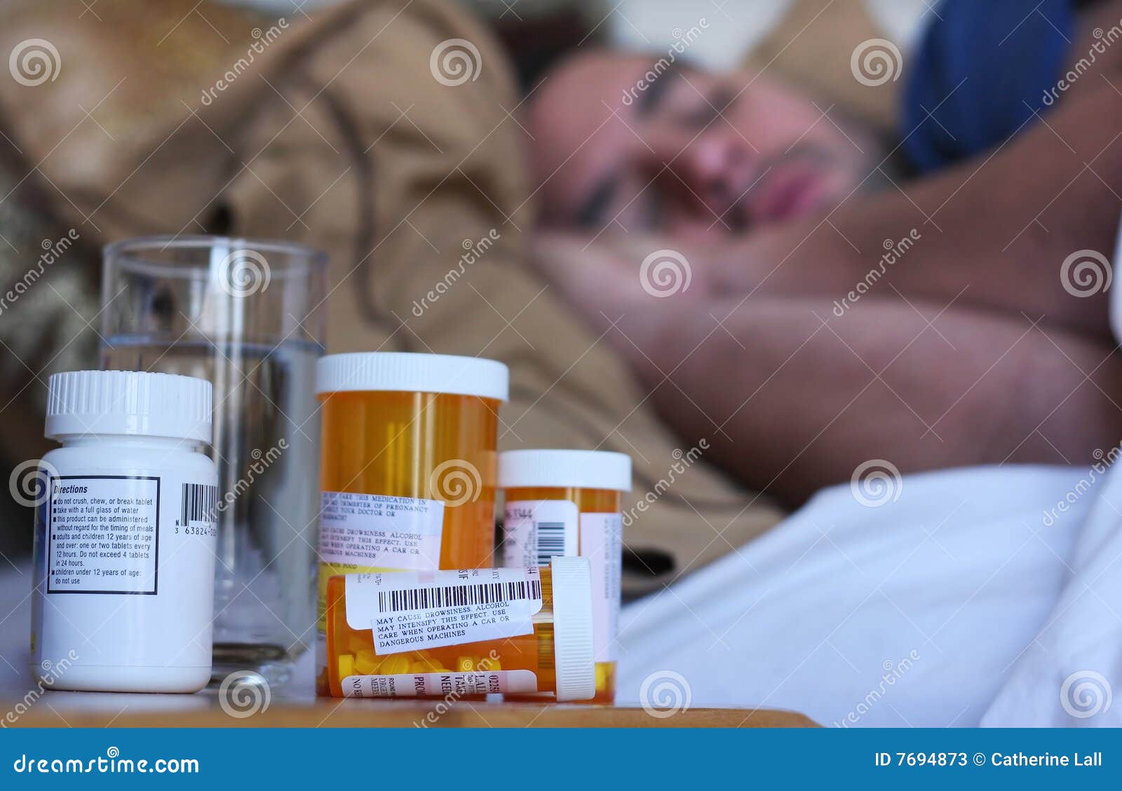 Doente na cama. Um doente do homem na cama com medicamentação da prescrição focalizou no primeiro plano