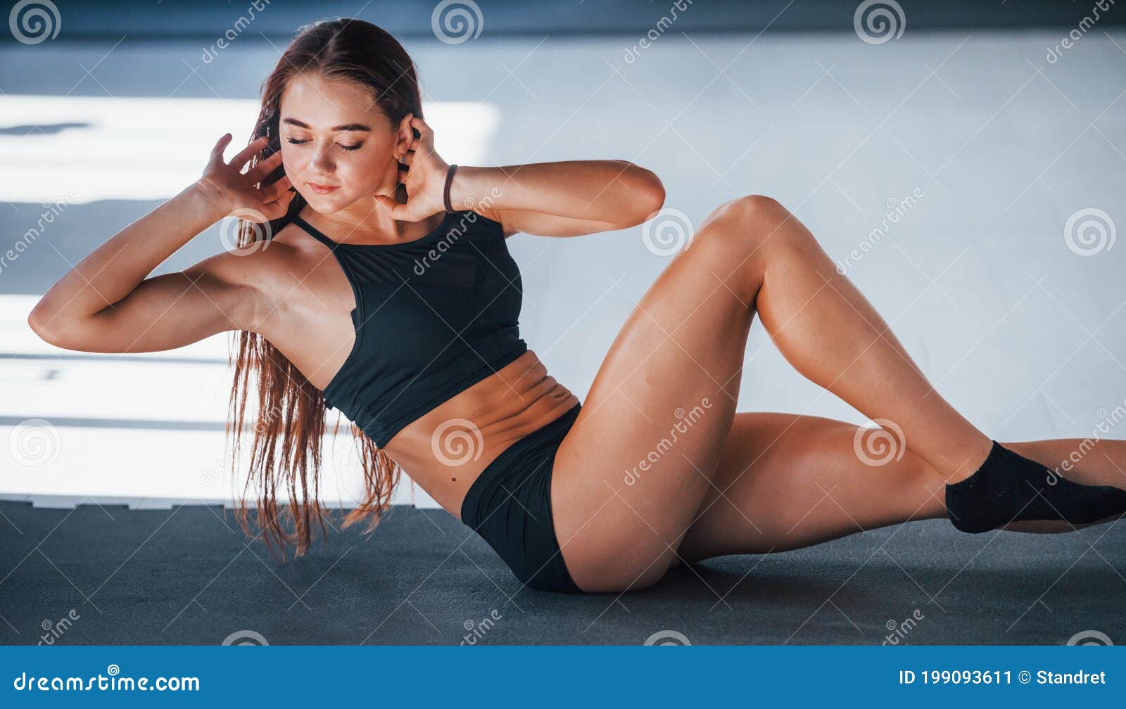 Young Slim Woman In Black Sporty Outfit Doing Gymnastics. Girl