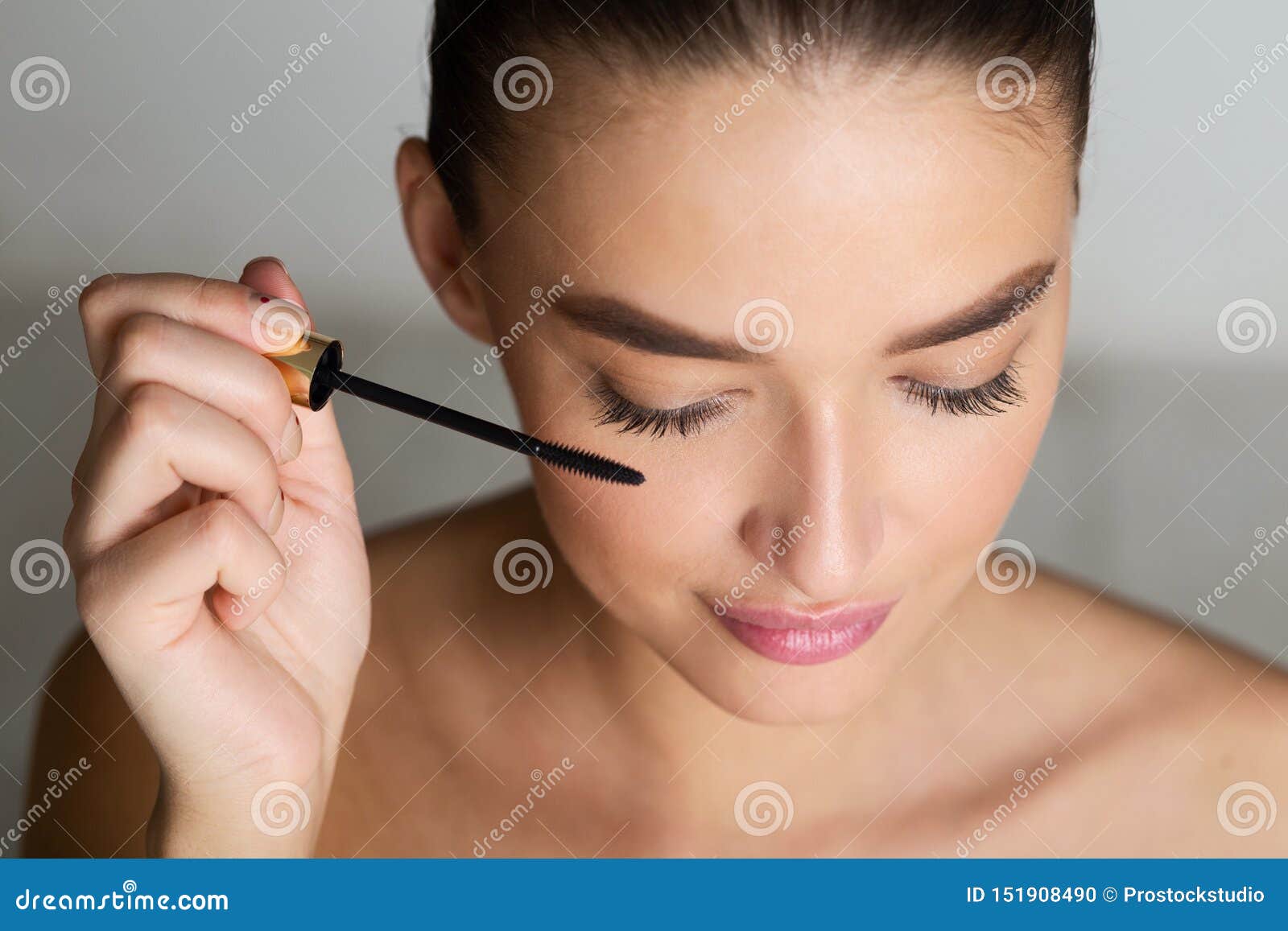 doing makeup. woman applying mascara on eyelashes