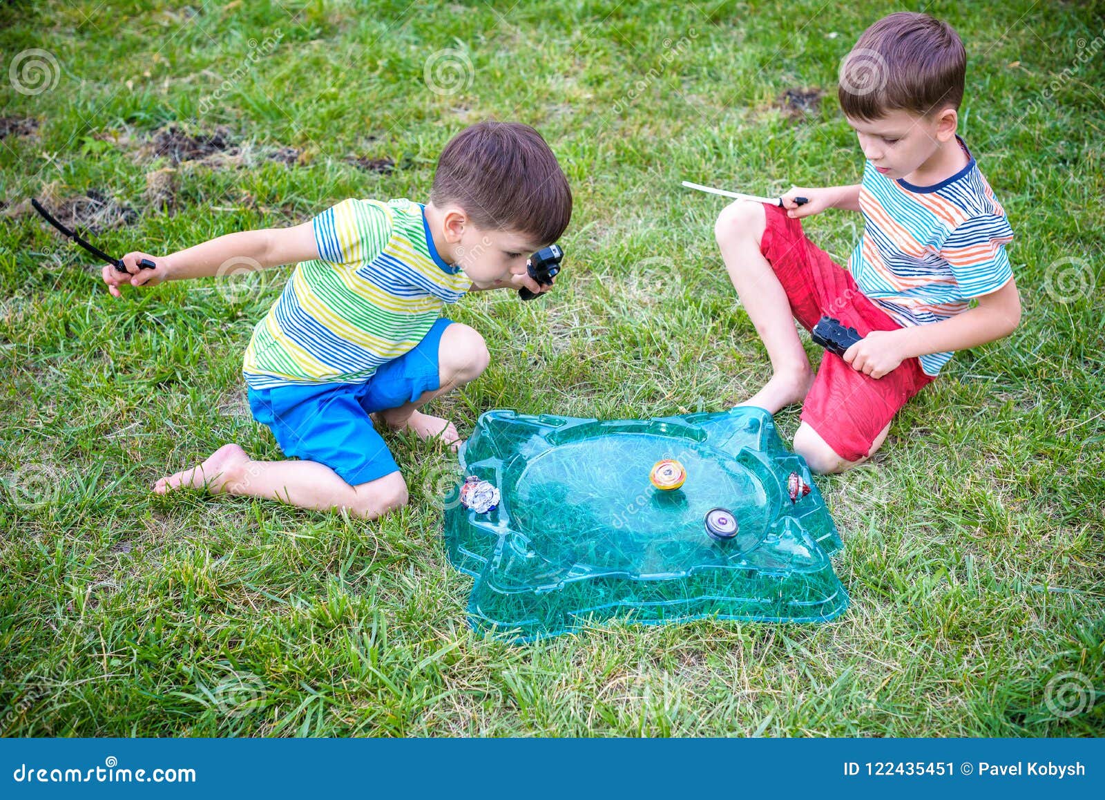 Dois Meninos Que Jogam Com Um Beyblade, Brinquedo Da Criança Da