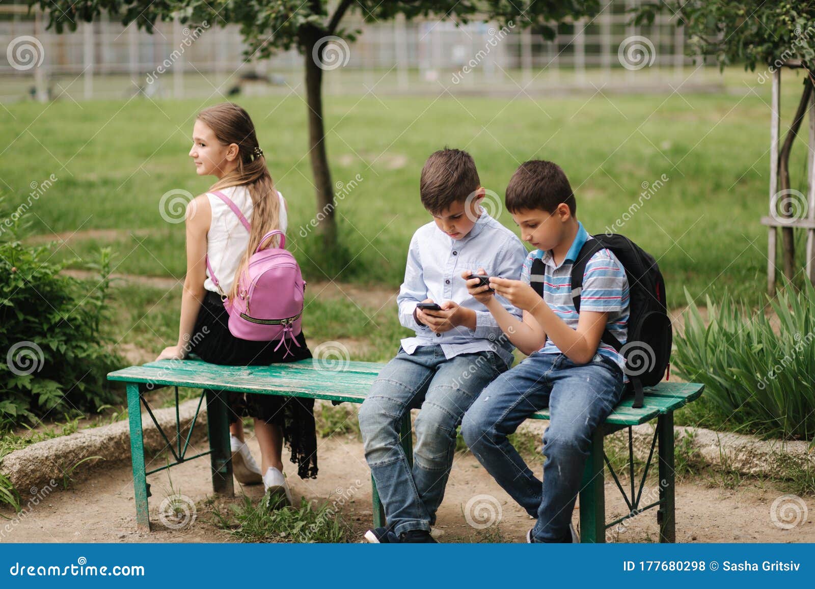 Menina olha como o menino joga o jogo online. dois meninos jogam jogos  online em quarentena. rapazes sorriem e